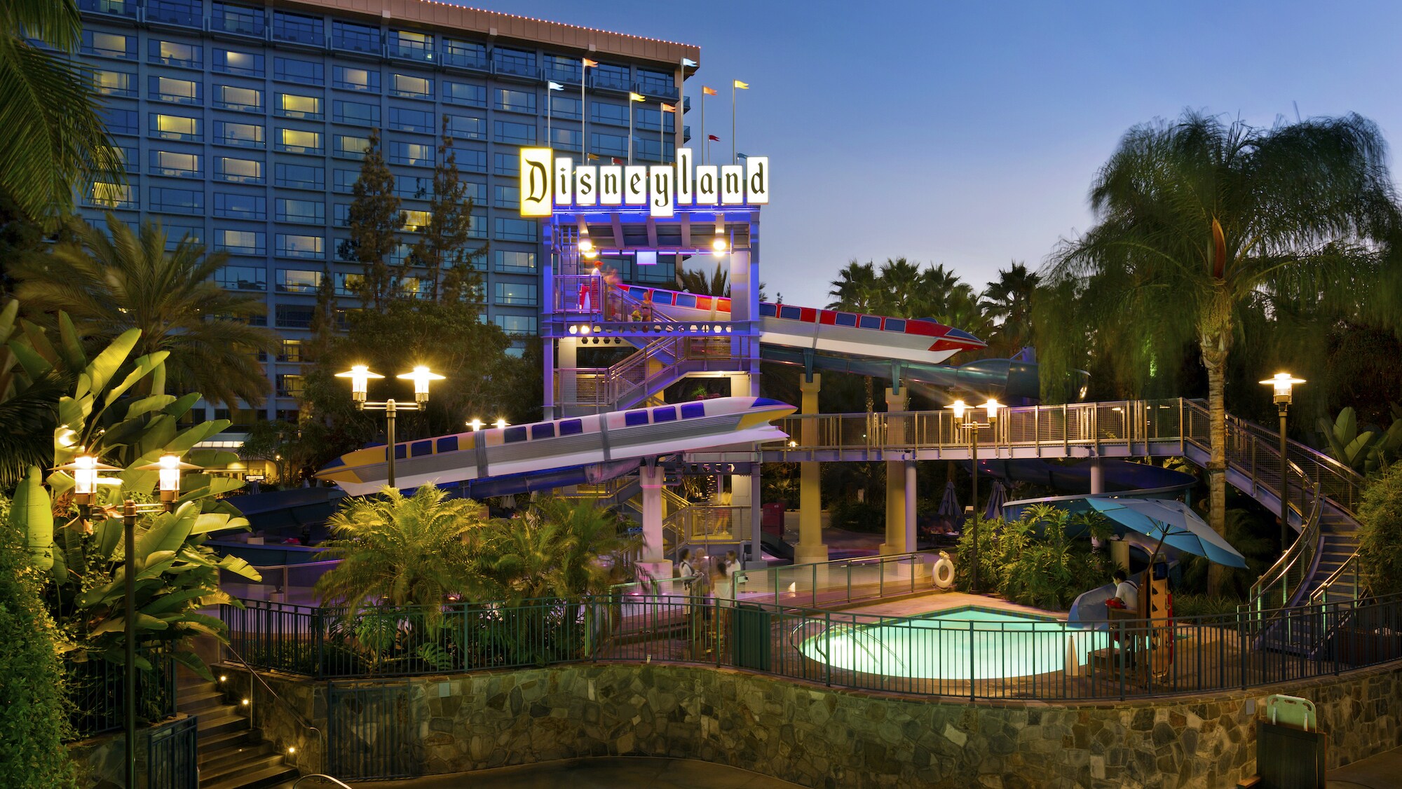 Image of the pool lit at dusk at the Disneyland Hotel.