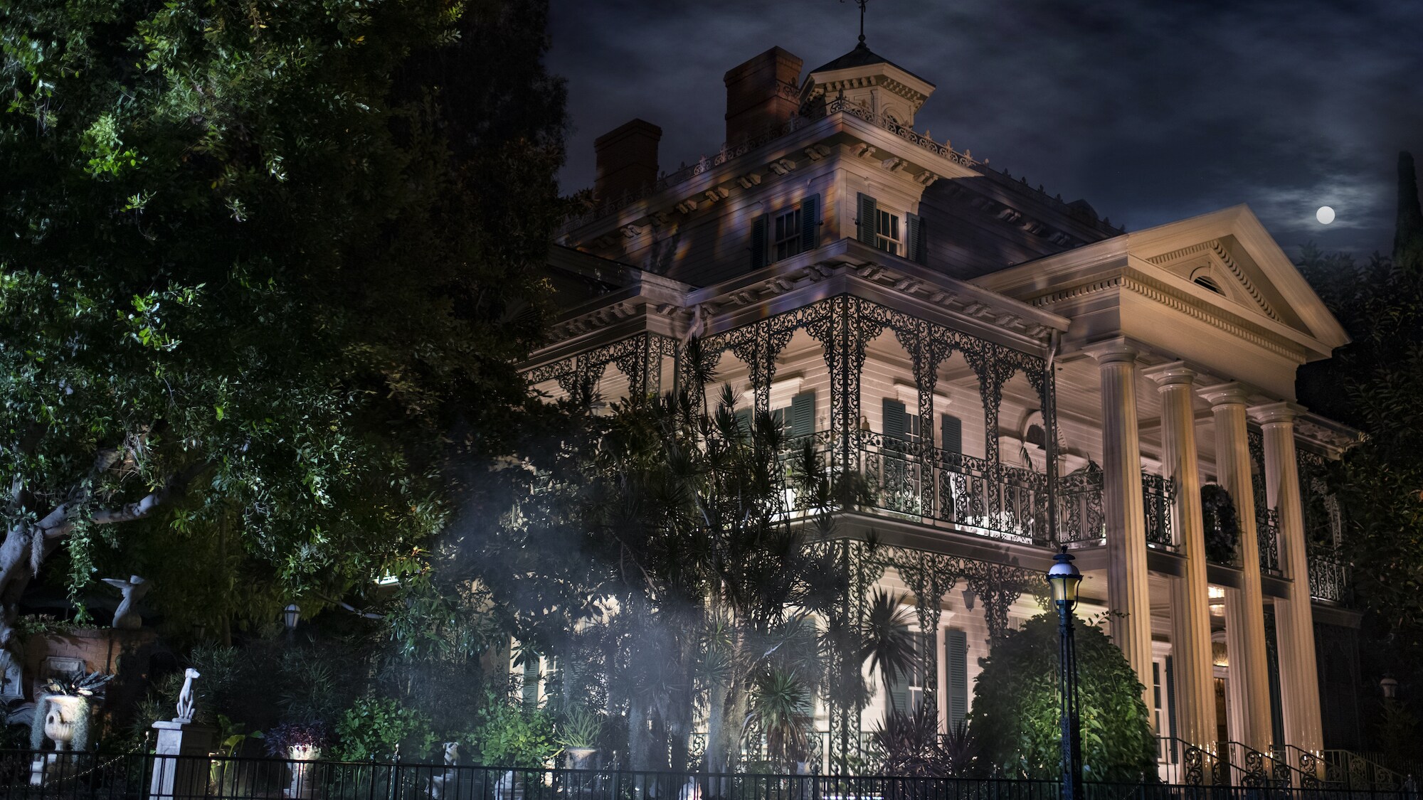 Image of the Haunted Mansion exterior at night.