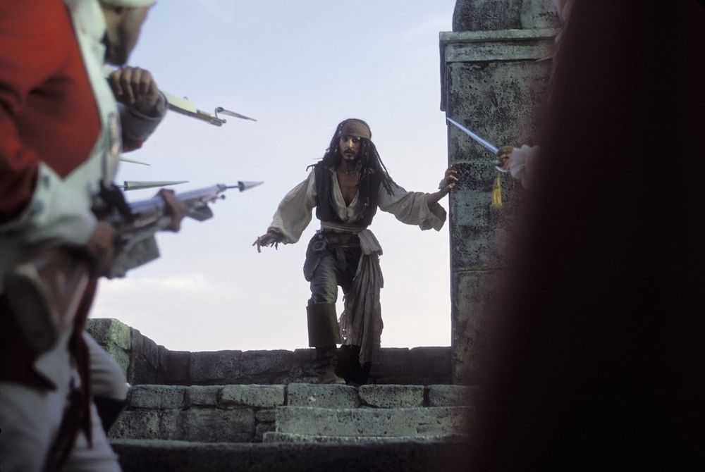 Actor Johnny Depp as Captain Jack Sparrow backed to a ledge by British soldiers