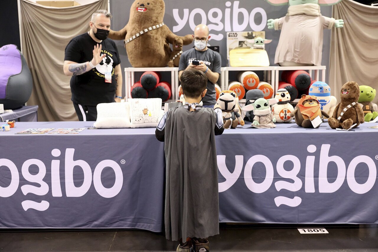A fan at Star Wars Celebration looking at a merch table