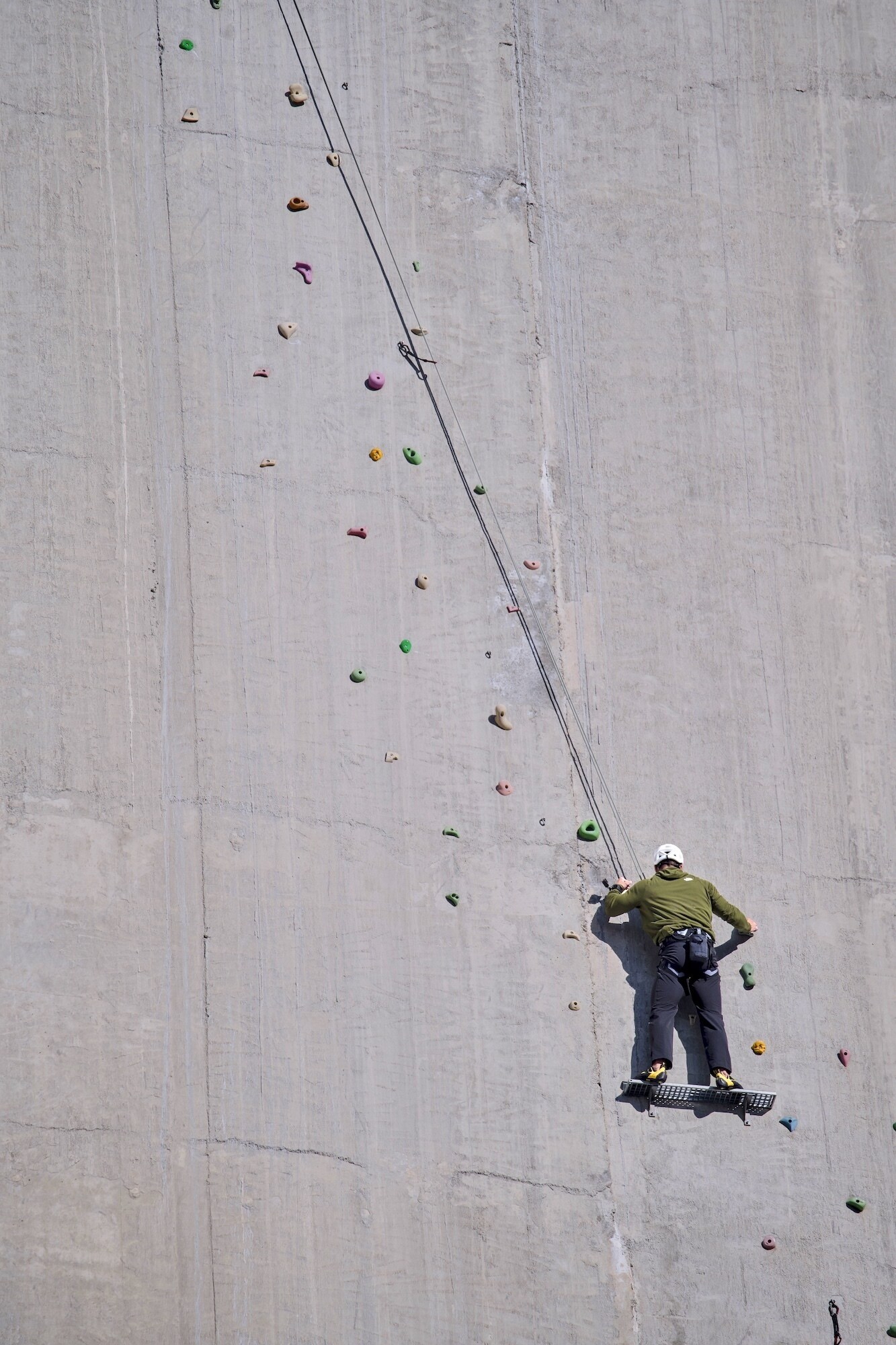 At the Luzzone dam in Switzerland, Chris rests on the platform at the start of three. He's made it to the sunlit area of the dam, and he needs to warm himself before taking on the next sections. (credit: National Geographic/BenMcGeorge-Henderson)
