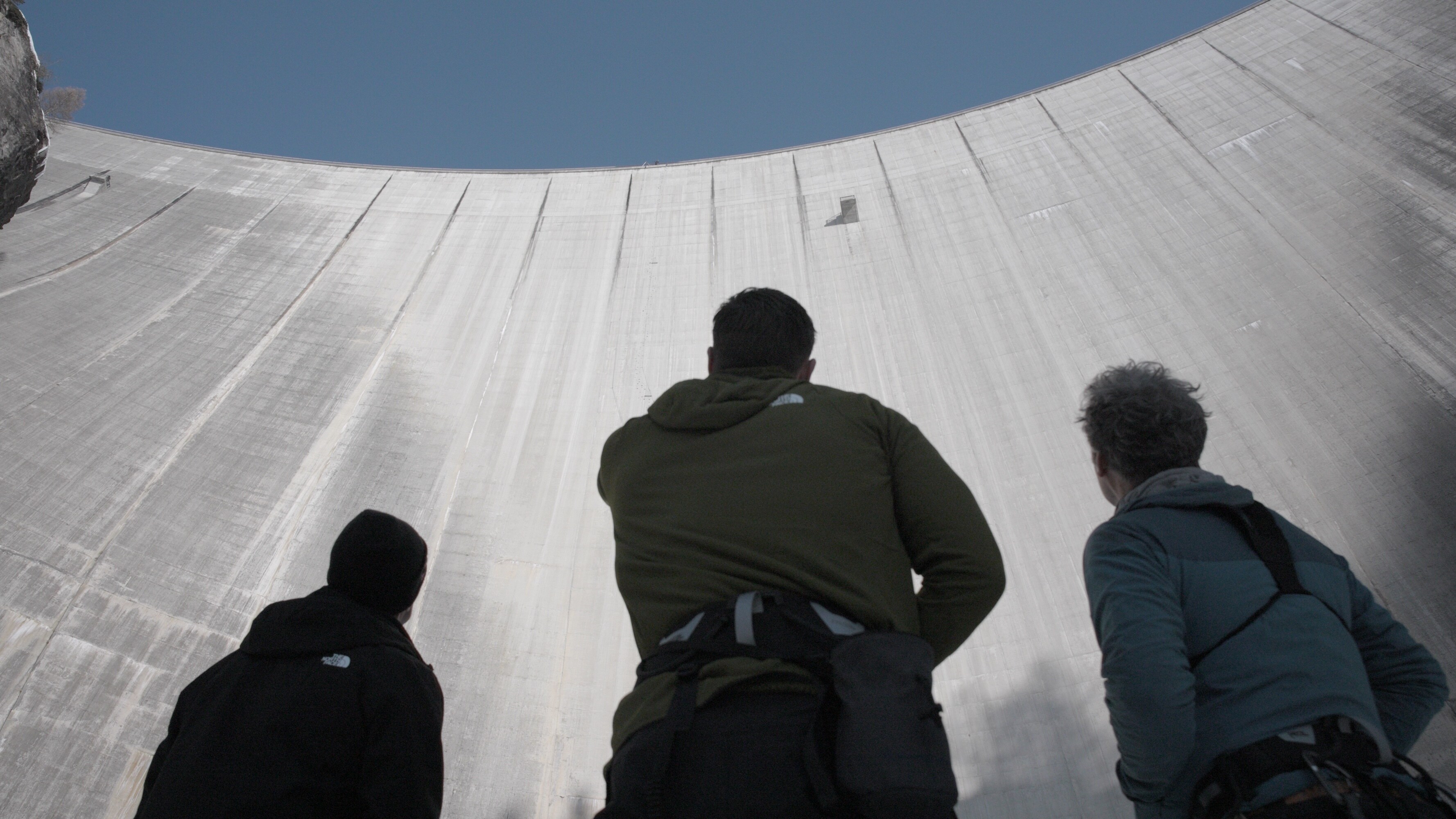 At the base of the Luzzone dam, in Switzerland, Chris, climbing expert Percy Bishton, right, and motocross stunt rider Robbie Maddison, left, talk through the climbing route.  (credit: National Geographic)