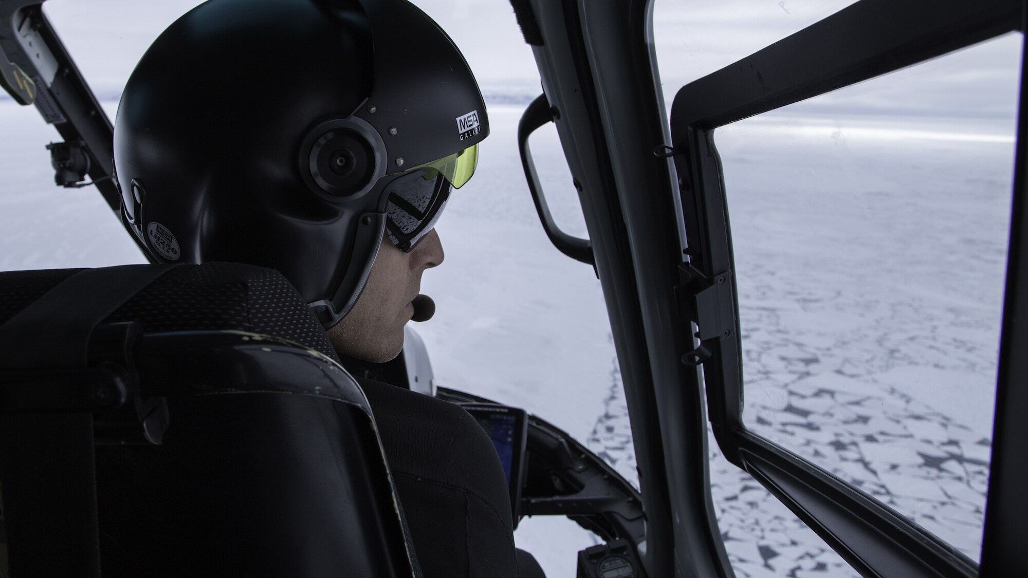 Pilot Paul Guarducci flies over broken sea ice in the Canadian Arctic. The Planet of the Whales team used a specialty rig on a helicopter to film narwhals and belugas from a distance - essential for capturing natural behavior. (National Geographic for Disney+/Sam LeGrys)