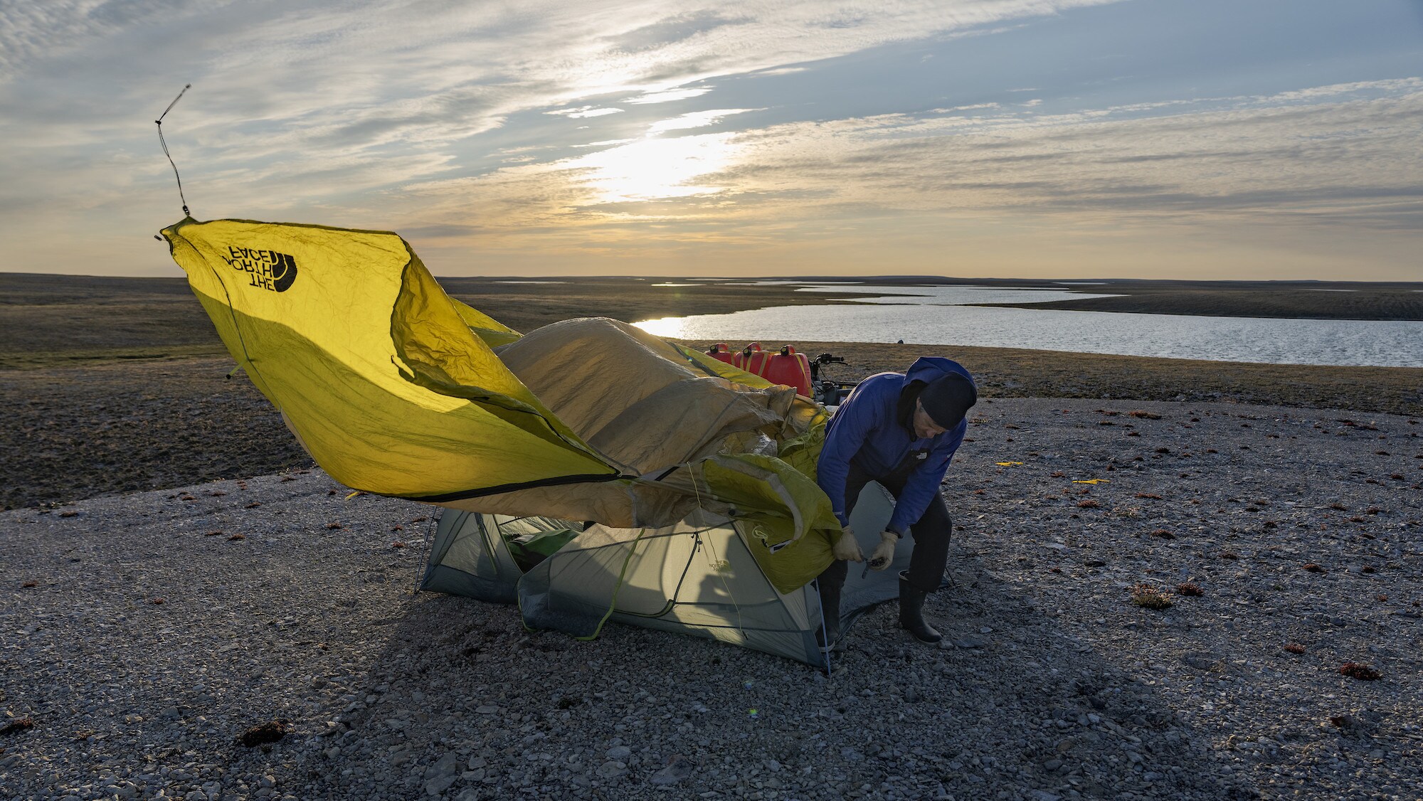 Explorer Mark Synnott ties his tent at base camp on King William Island, Nunavut, Canada. He is part of a team searching for Sir John Franklin's lost tomb on King William Island, Nunavut, Canada. (National Geographic/Renan Ozturk)