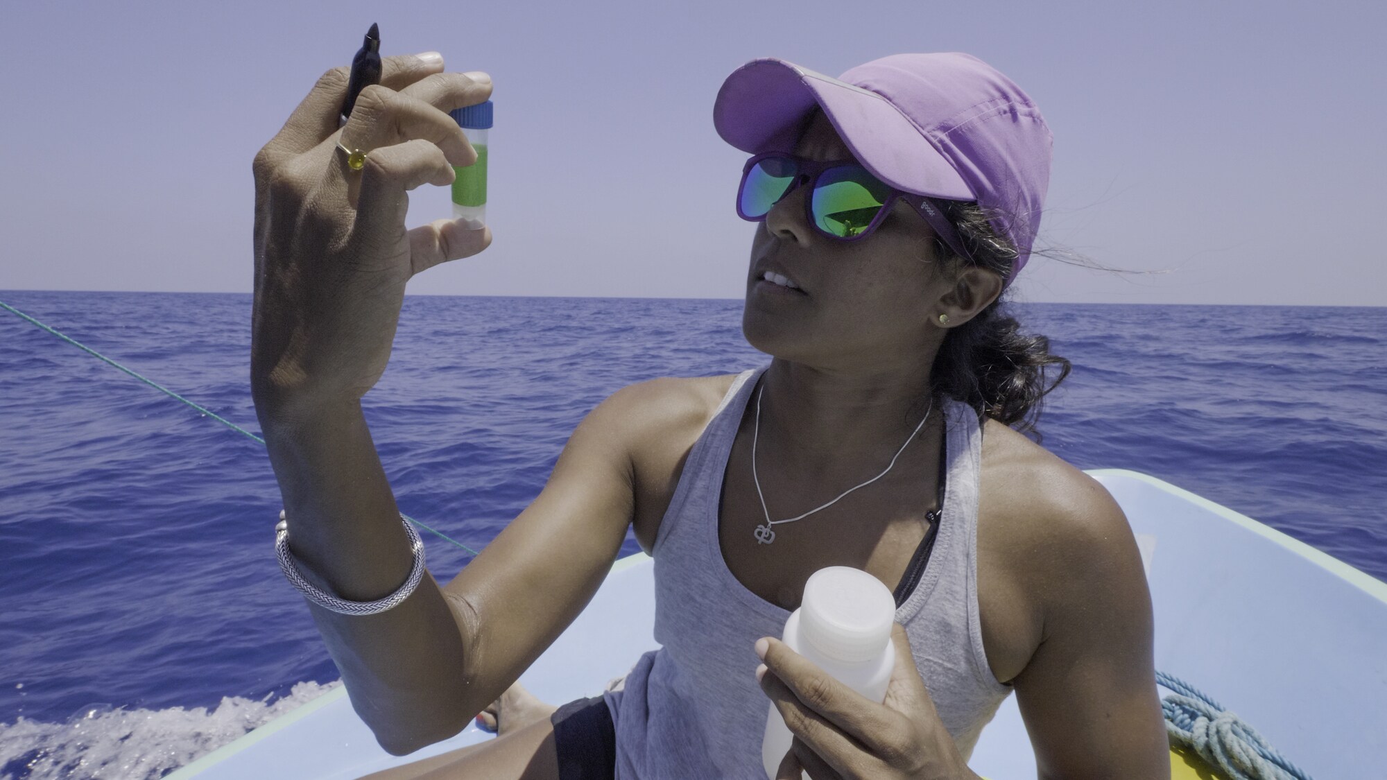 Marine biologist Asha DeVos studies a sample of sperm whale dung, which will give her clues into what the whales are eating. (National Geographic for Disney+/Andrew Mitchell)