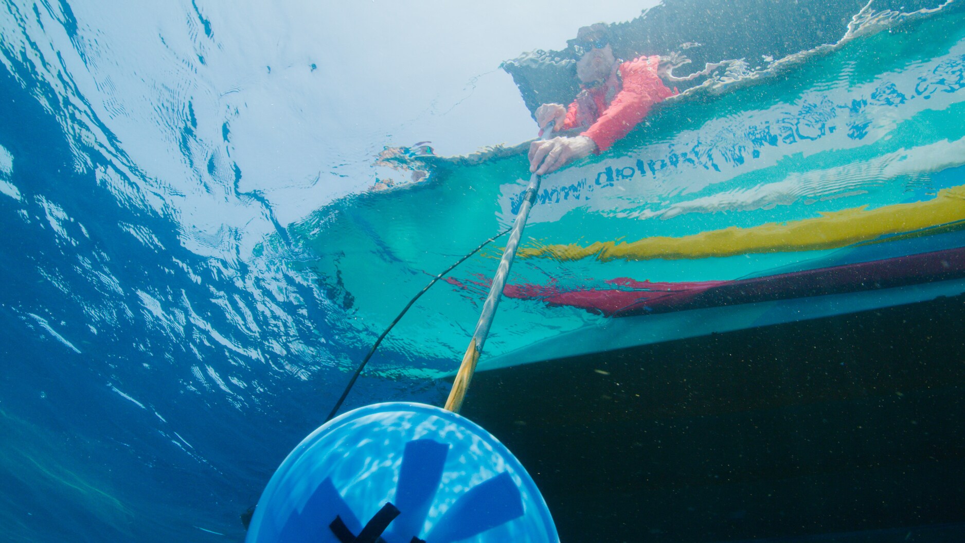 Marine biologists Shane Gero and Asha DeVos eavesdrops on sperm whale conversations with a hydrophone. They are listening for dialects that separate whale populations. (National Geographic for Disney+/Luis Lamar)