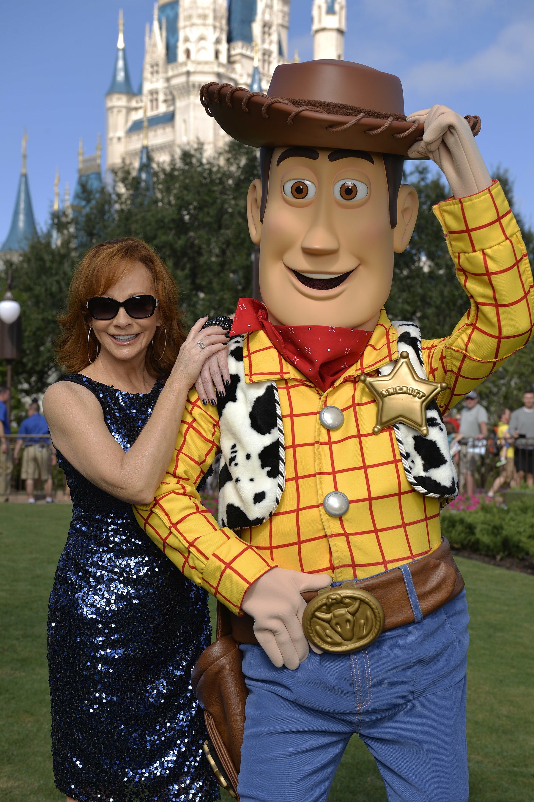 Reba McEntire poses Nov. 11, 2015 with Woody from Disney-Pixar "Toy Story" during a break from ta...