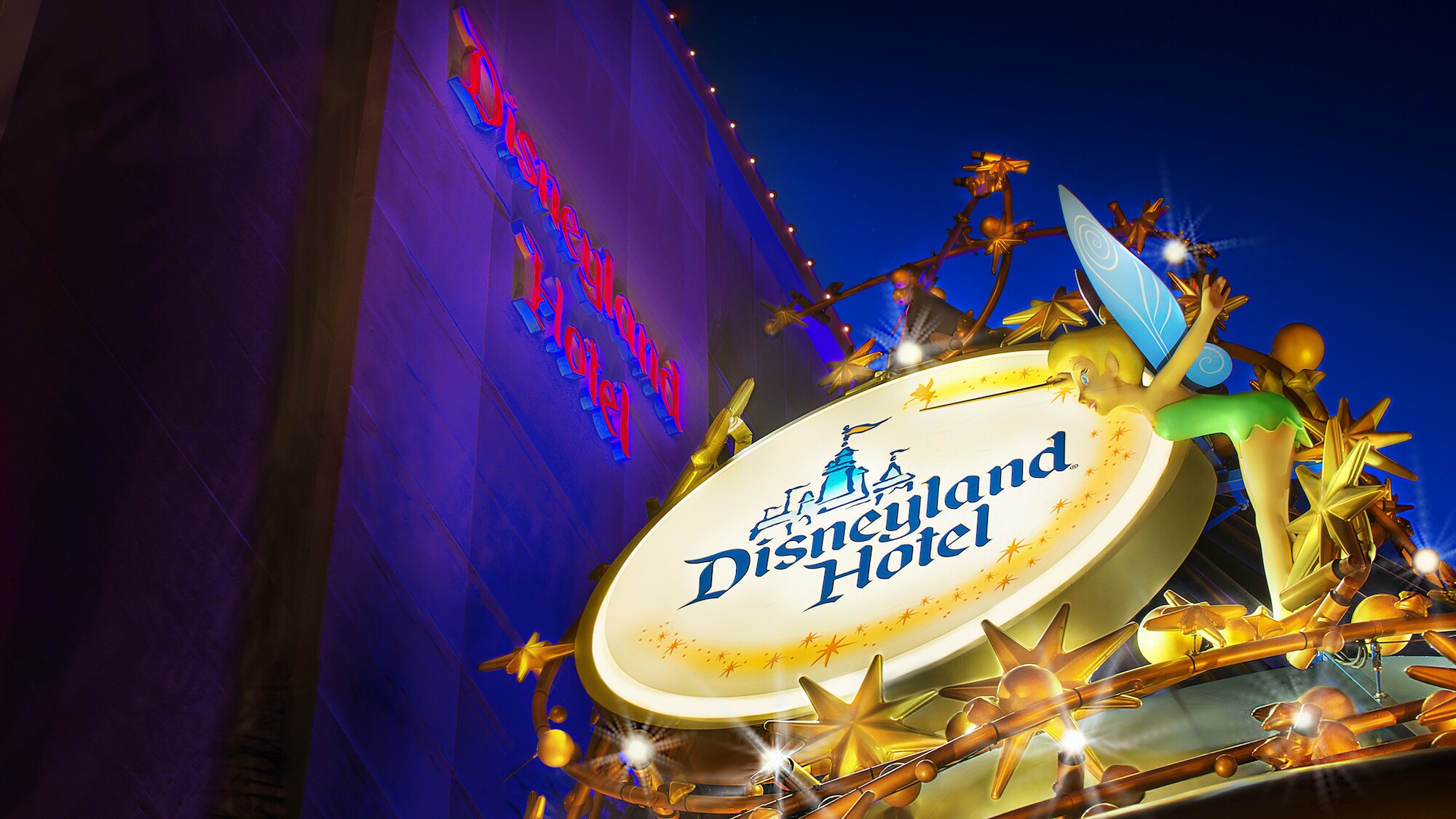 Image of the lit Disneyland Hotel sign.