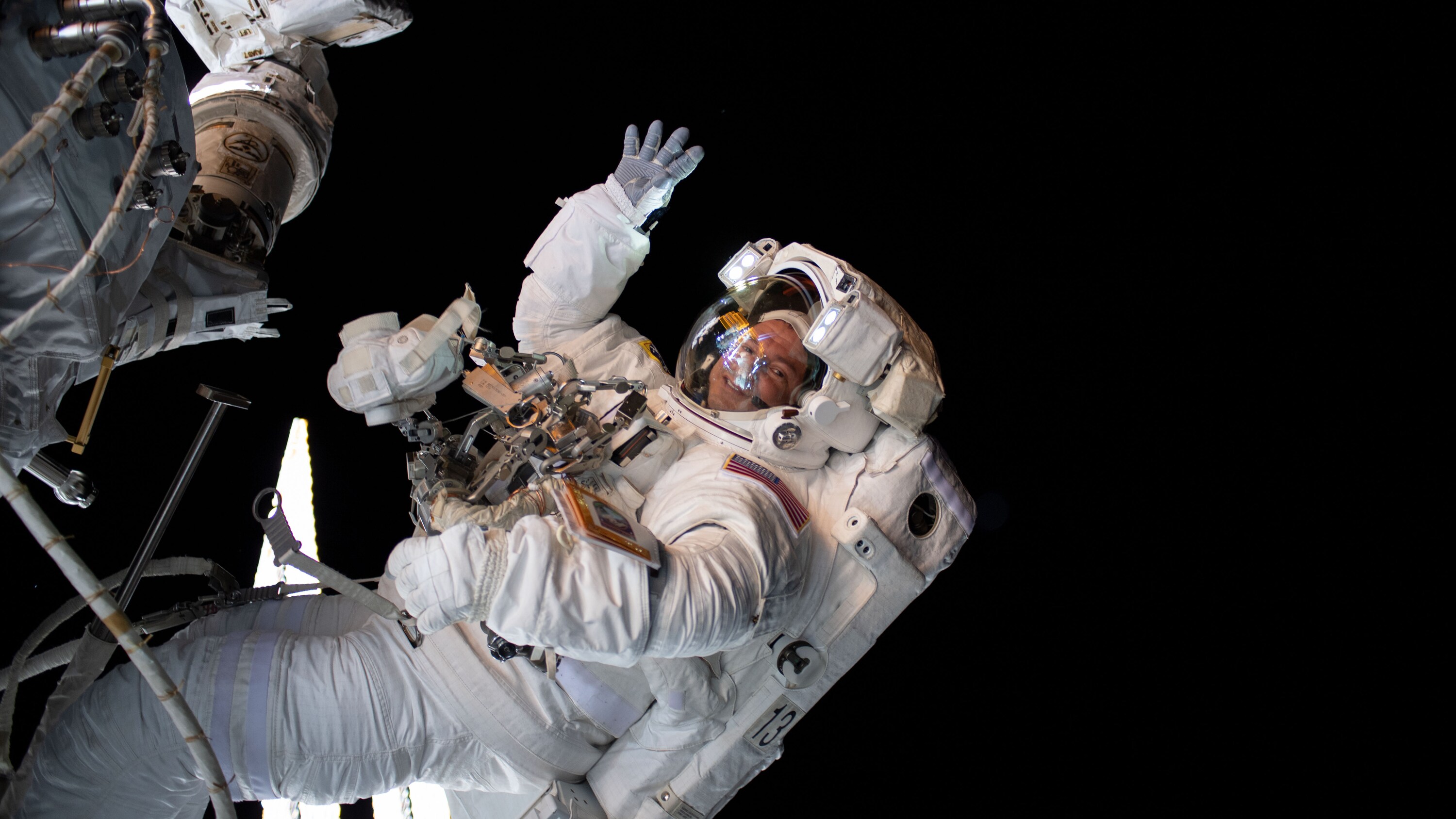 AMONG THE STARS - (Aug. 21, 2019) - NASA astronaut Andrew Morgan waves as he is photographed during a spacewalk to install the International Space Station’s second commercial crew vehicle docking port, the International Docking Adapter-3 (IDA-3). (NASA) ANDREW MORGAN