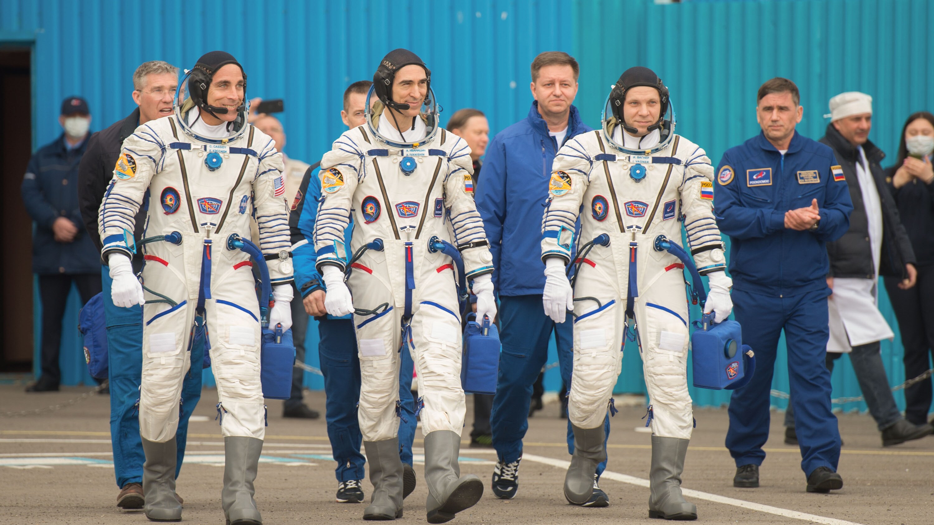 AMONG THE STARS - Expedition 63 crewmembers Chris Cassidy of NASA, left, Anatoly Ivanishin, center, and Ivan Vagner of Roscosmos, depart building 254 for the launch pad, Thursday, April 9, 2020 at the Baikonur Cosmodrome in Kazakhstan. A few hours later, they lifted off on a Soyuz rocket for a six-and-a-half month mission on the International Space Station. (NASA/GCTC/Andrey Shelepin) CHRIS CASSIDY, ANATOLY IVANISHIN, IVAN VAGNER