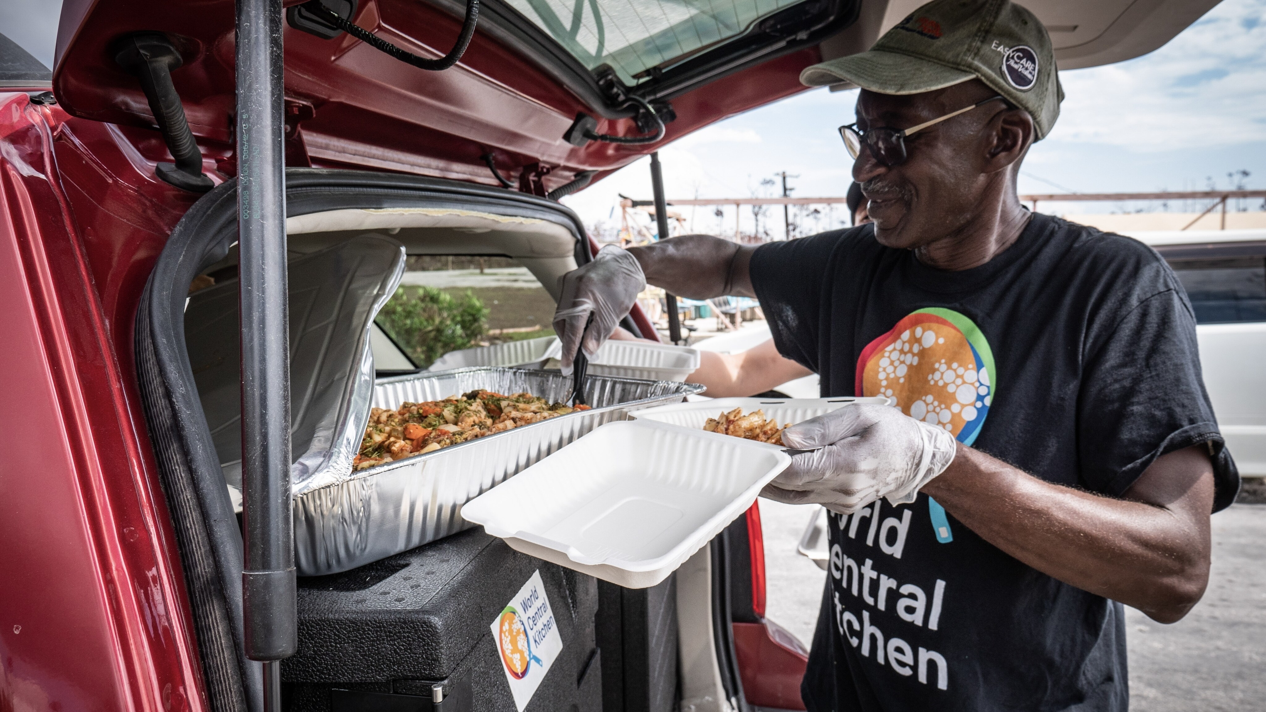 World Central Kitchen volunteer, Kenton Rocker, plates food from the back of a WCK van. (Credit: National Geographic)