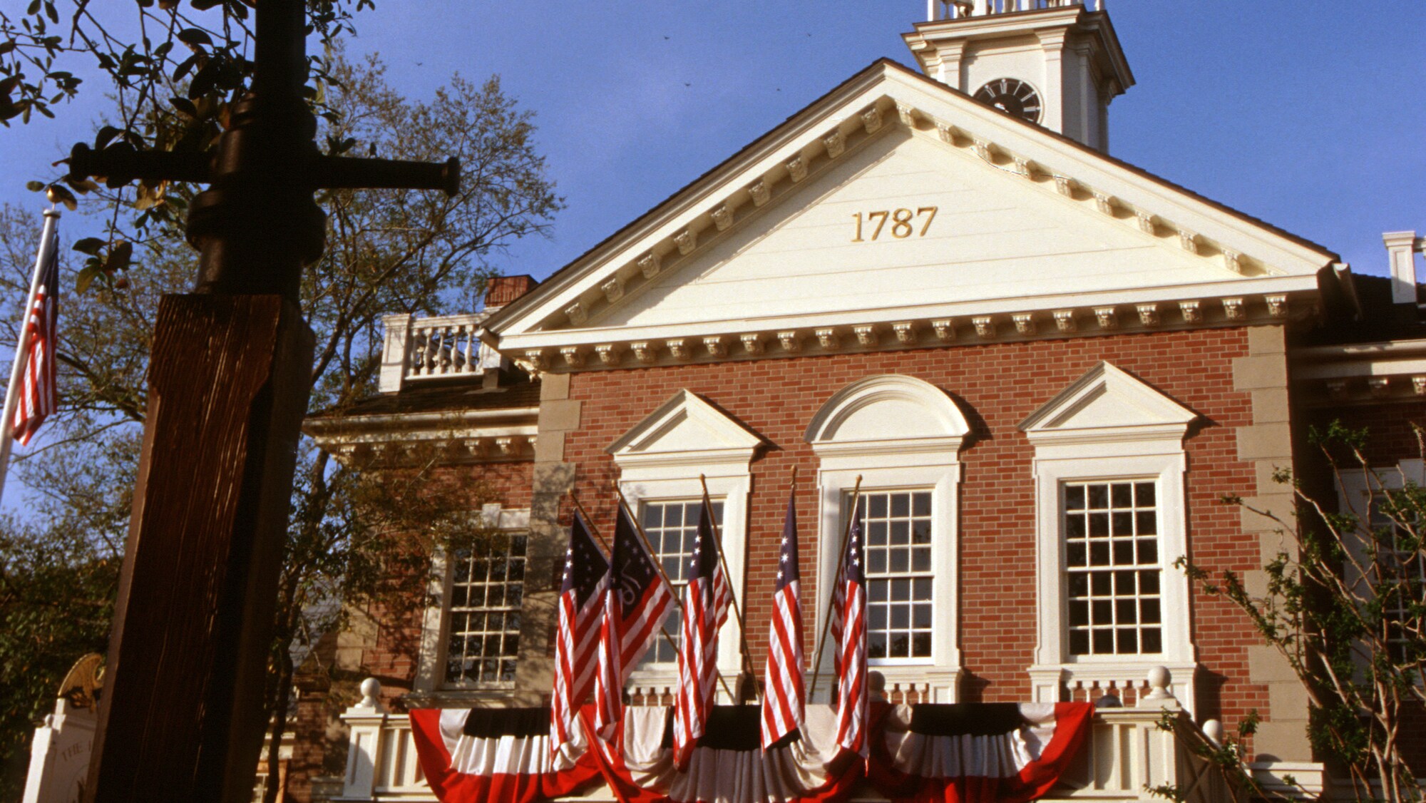 Image of The Hall of Presidents building exterior displaying American flags.