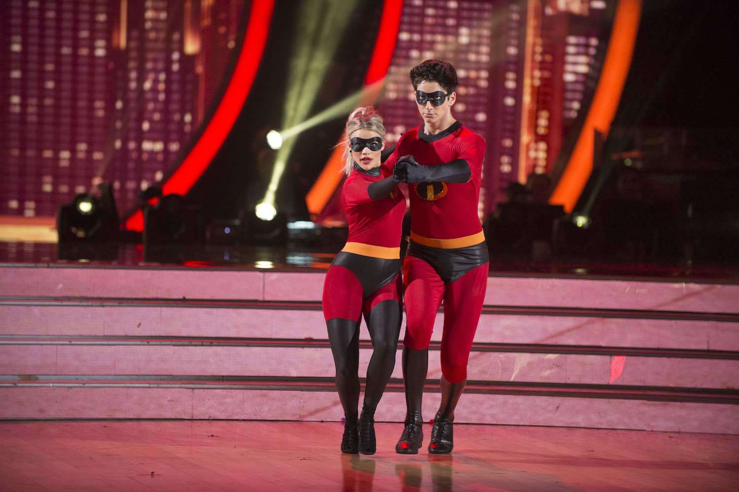 Milo Manheim and Witney Carson dancing in matching Incredibles-inspired super suits