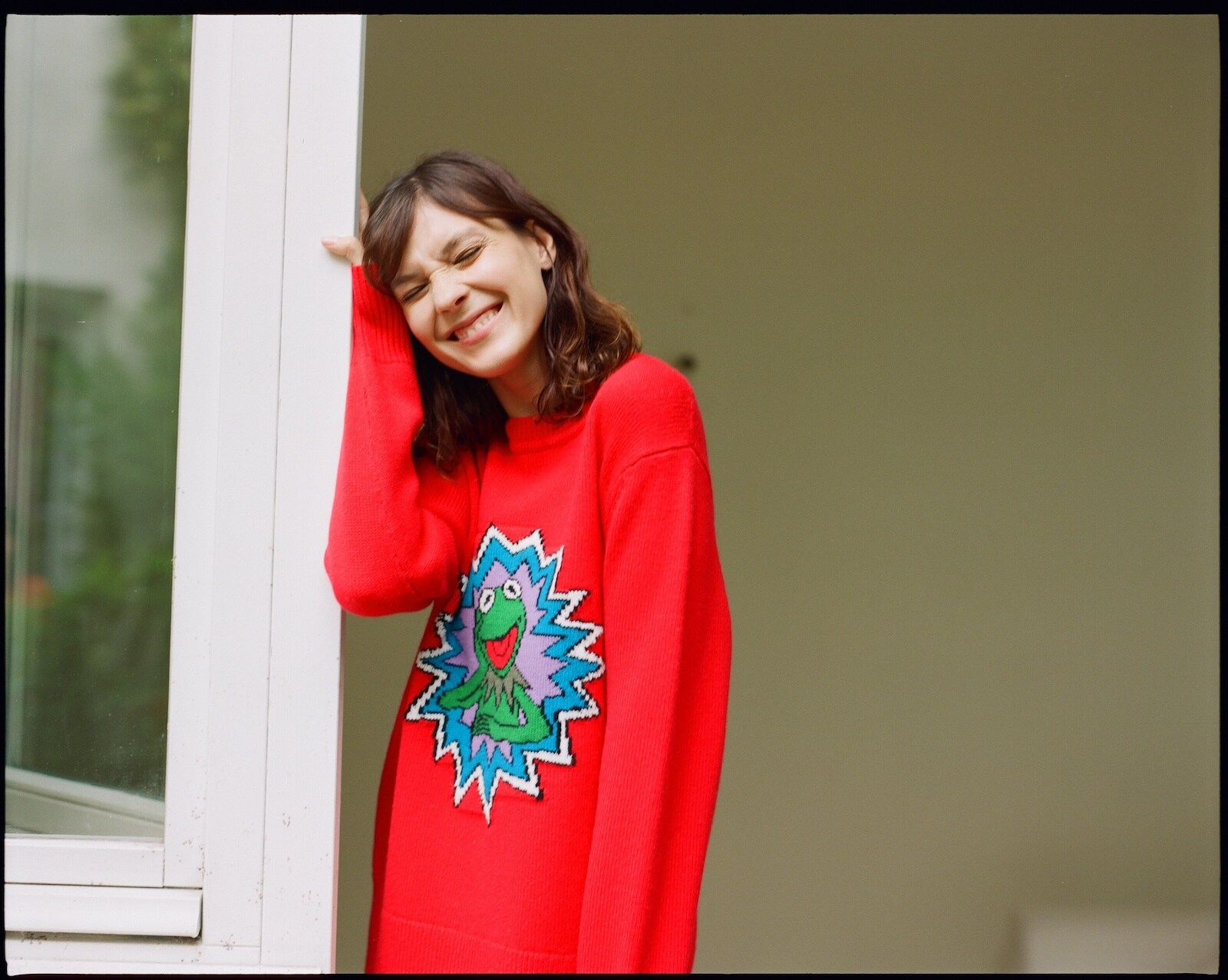 Model wearing red sweatshirt featuring Kermit from the Sandro collection