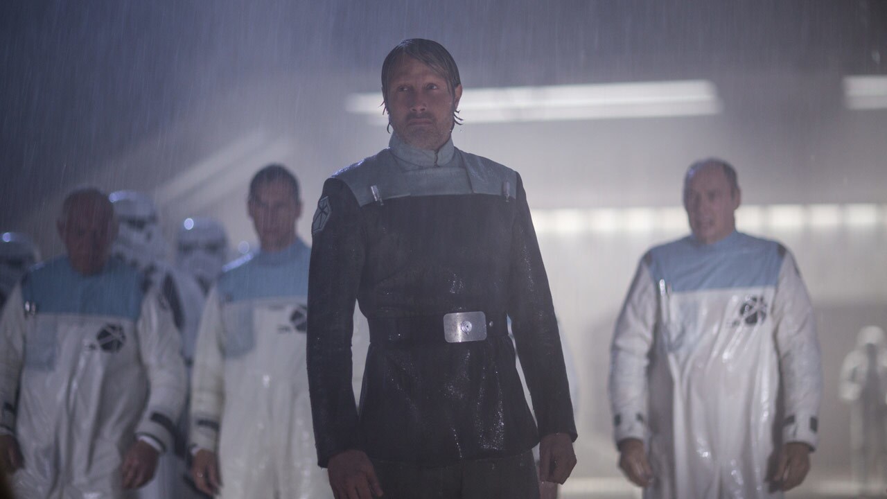 Galen and his team meet with Krennic on a landing platform. Krennic demands to know which science...