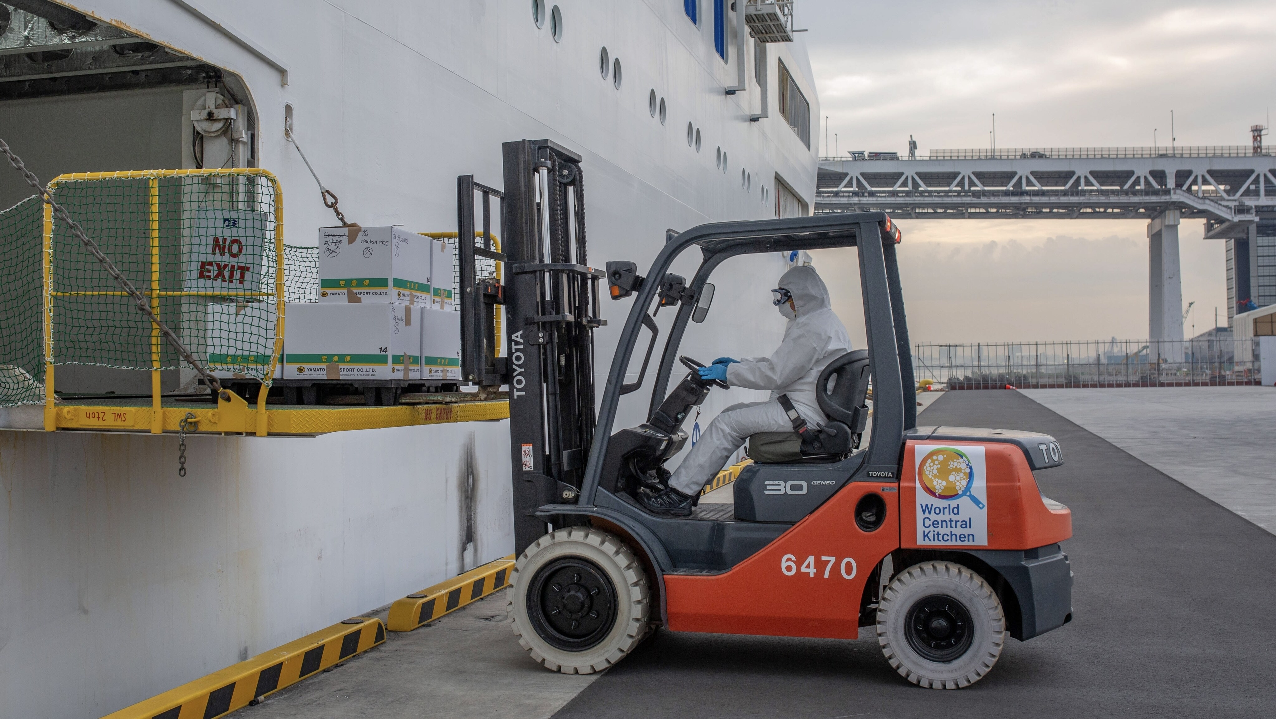 World Central Kitchen team member in full hazmat suit shuttles meals on forklift to quarantined travelers on the Diamond Princess cruise ship. (Credit: National Geographic/Clara Wetzel)