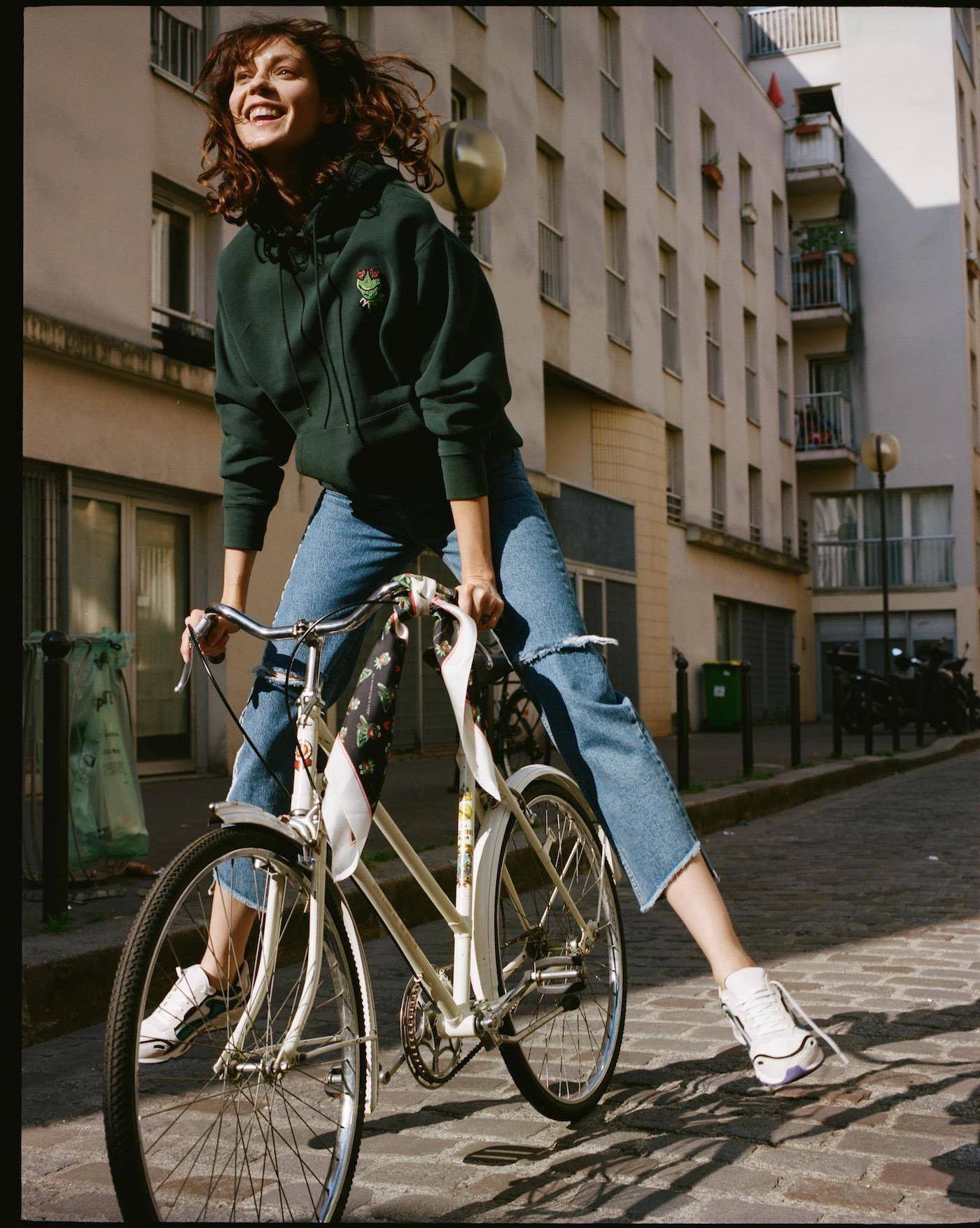 Model wearing green hoodie featuring Kermit from the Sandro collection