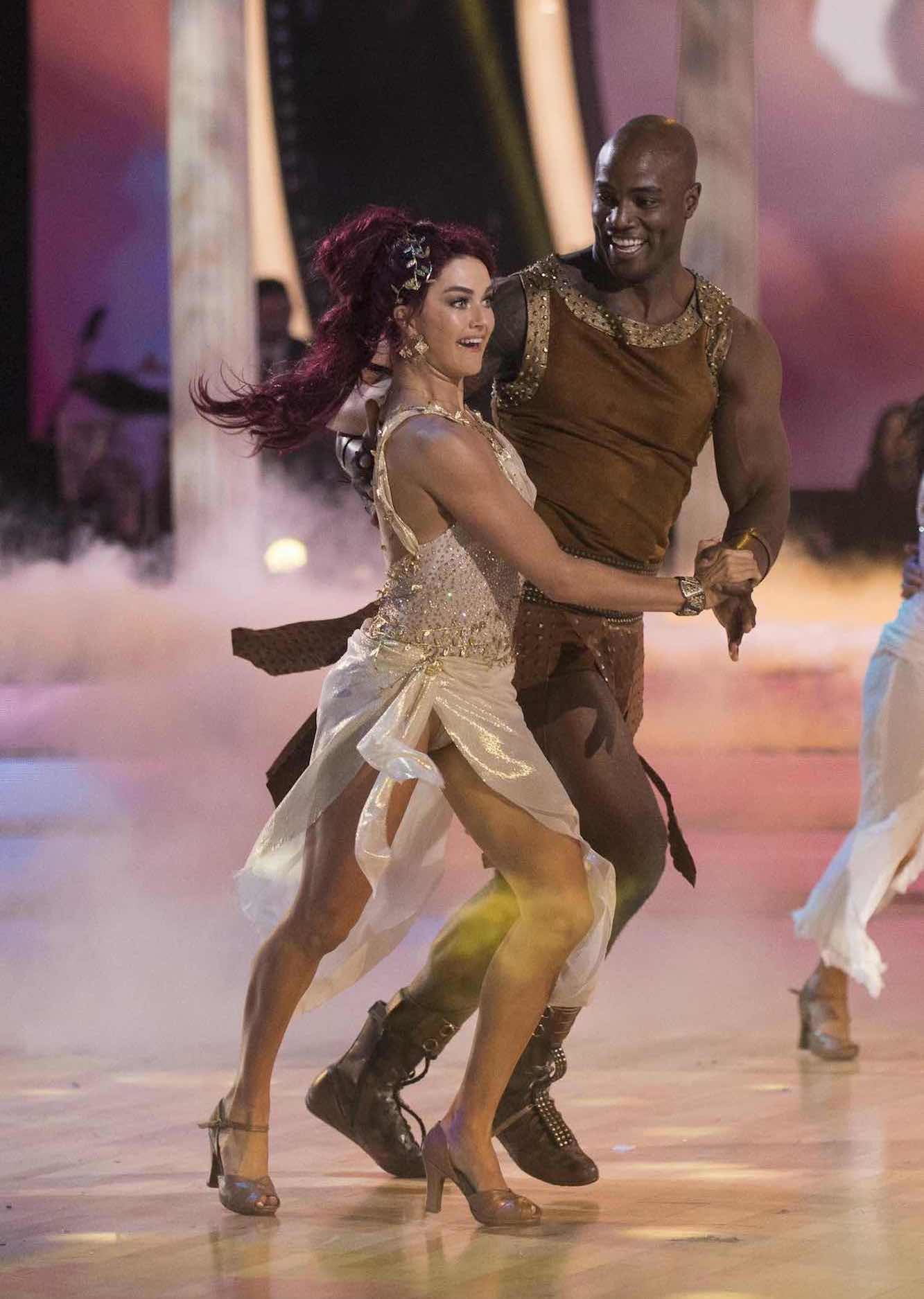 DeMarcus Ware and Lindsay Arnold dancing, dressed as characters from Hercules 