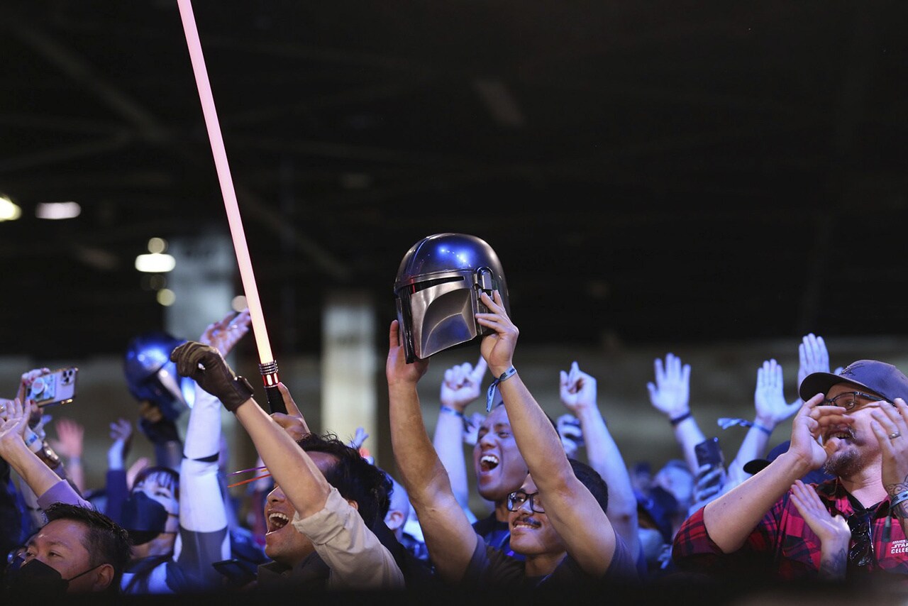 A Mandalorian helmet being held up in the crowd at Star Wars Celebration Anaheim