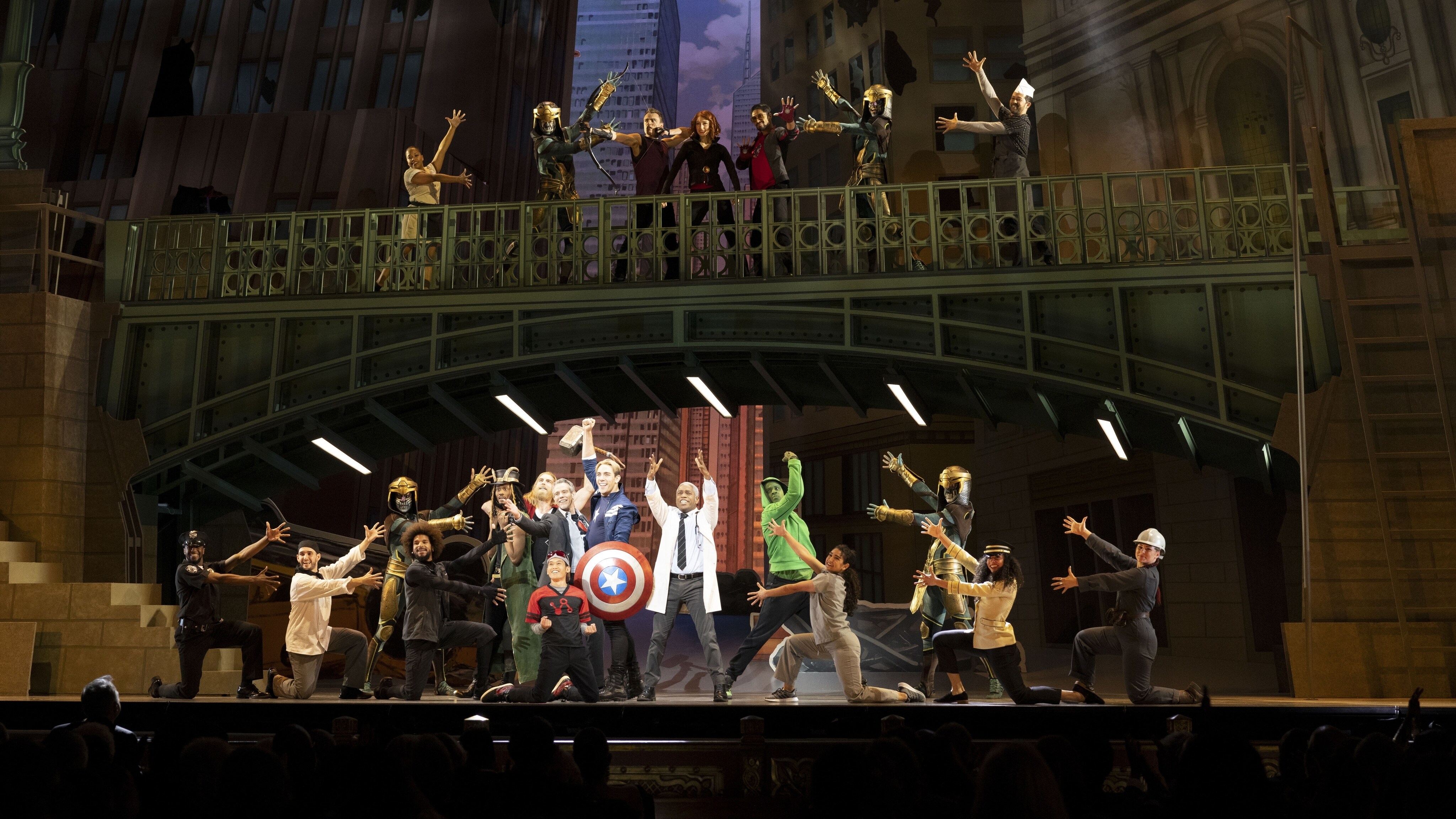 Avery Gillham as Musical Hawkeye, Meghan Manning as Musical Black Widow, Aaron Nedrick as Musical Iron Man, Jason Scott Macdonald as Musical Thor, Adam Pascal as lead, Nico Dejesus as Musical Ant-Man, Tom Feeney as Musical Captain America, Ty Taylor as lead, and Harris Turner as Musical Hulk in a scene still from Marvel Studios' HAWKEYE. Photo by Chuck Zlotnick. ©Marvel Studios 2021. All Rights Reserved.