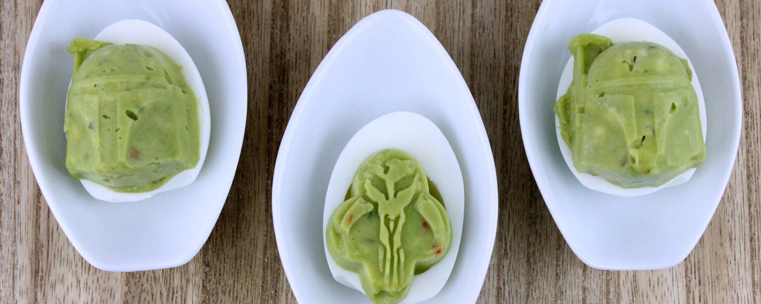 Boba Fett Guacamole Deviled Eggs, which showcase Boba Fett with his Mandalorian armor made out of a guacamole filling, sit in three bowls.