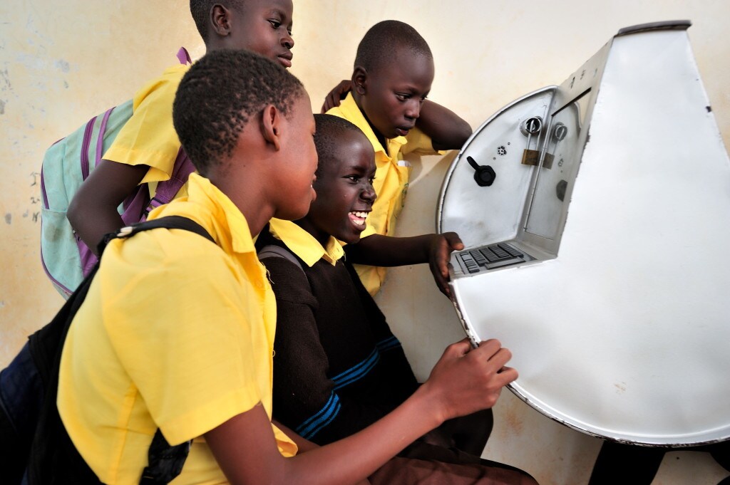 Young Ugandans gather around to use UNICEF's unique innovation the solar-powered Digital Drum, at Bosco Youth Centre in Gulu, Uganda.