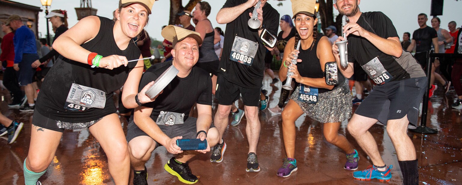 Participants of the runDisney Star Wars Rival Run hold miniature instruments and strike a pose for the camera.