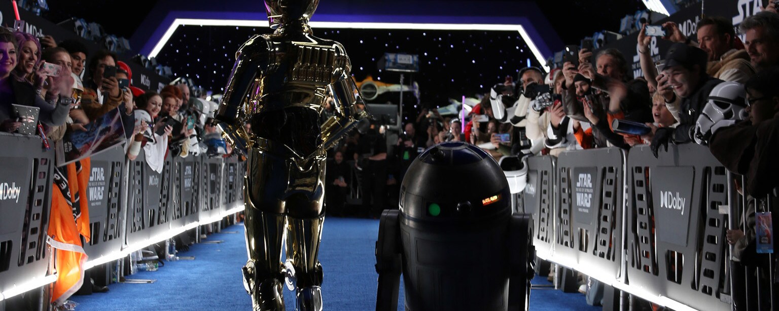 Fan greet R2-D2 and C-3PO on the blue carpet.