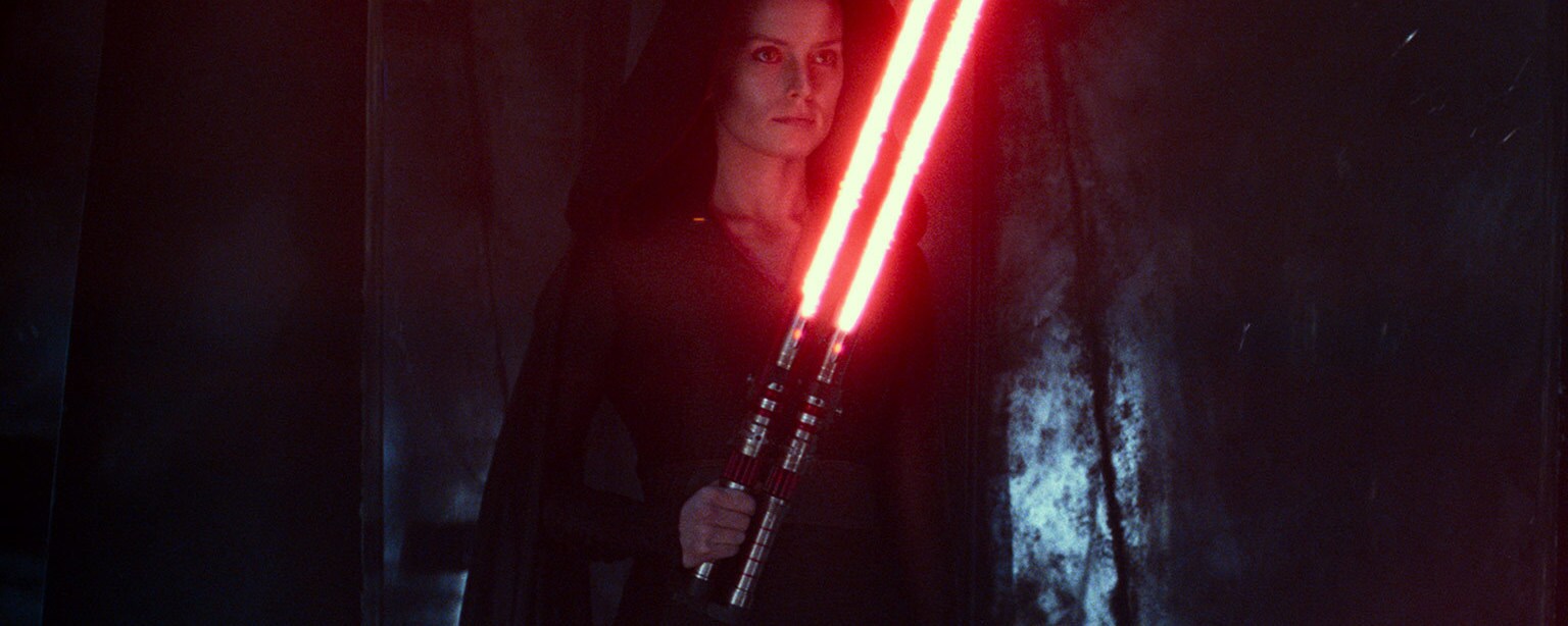 Dark Rey holds a dual-bladed lightsaber.