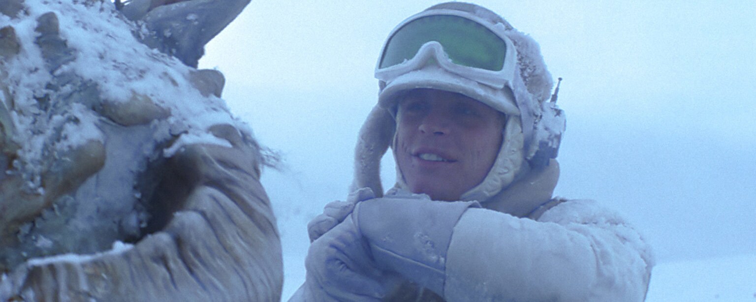 Luke Skywalker speaks into his communicator while riding a tauntaun.