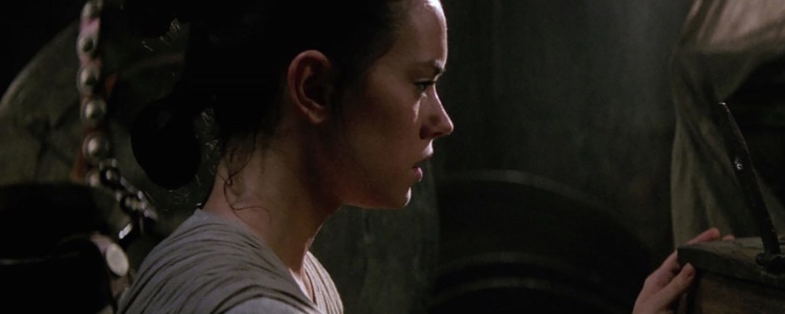 Rey opens a chest in the basement of Maz's castle.