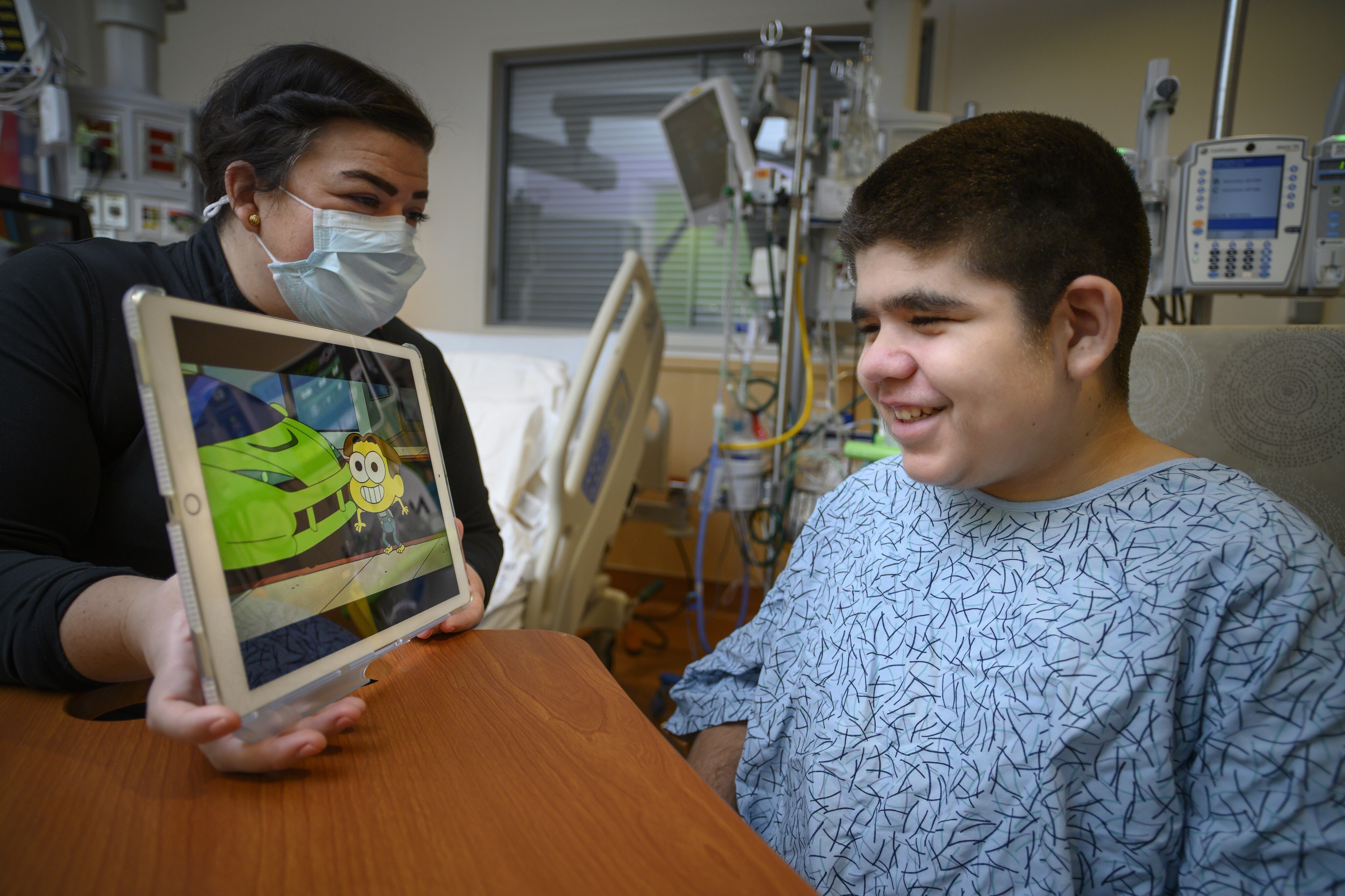 Young boy in hospital watching Disney+ on a iPad