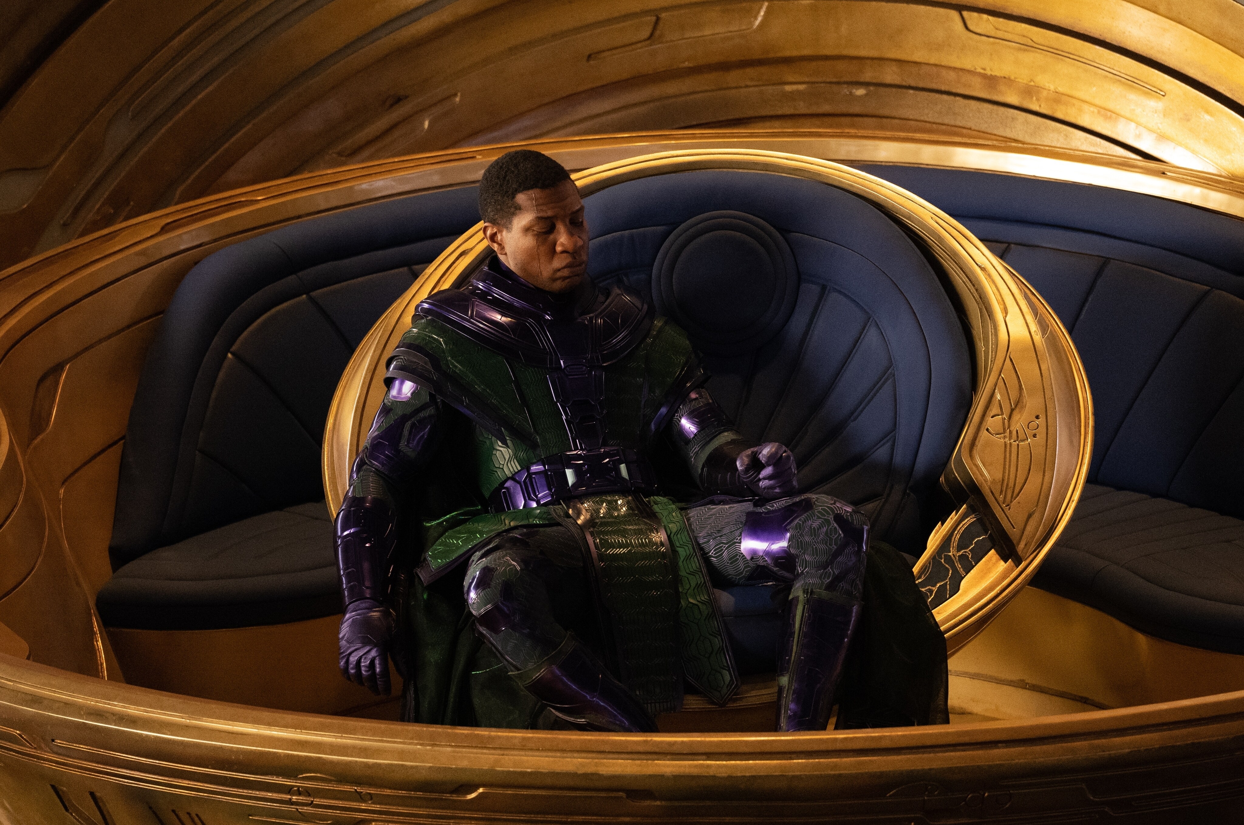 Kang the Conqueror sits in a circular throne-like chair