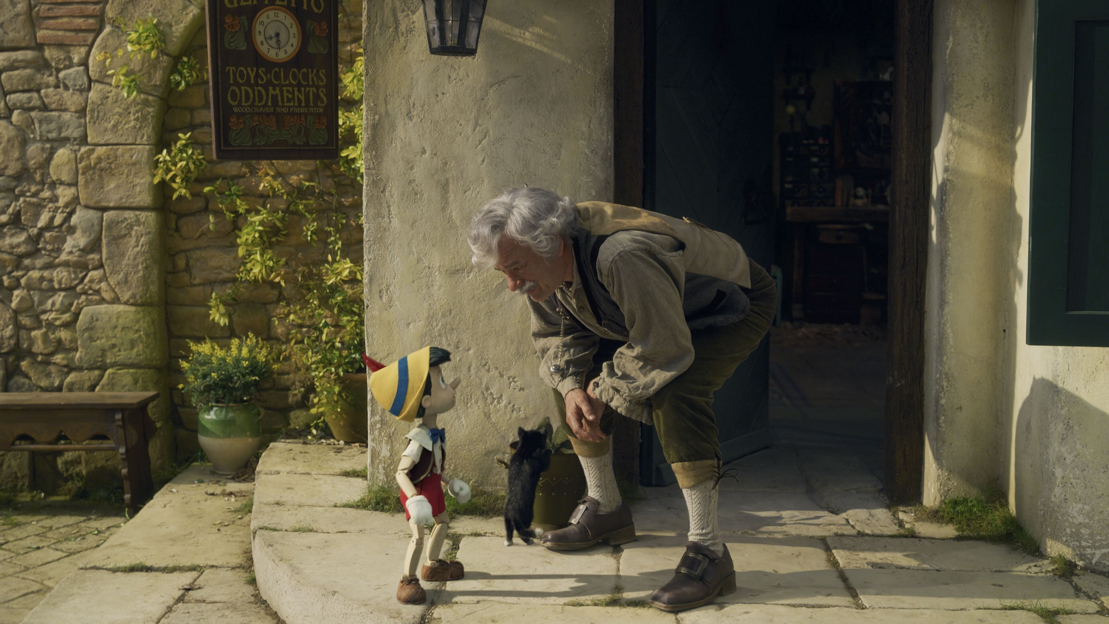 (L-R): Pinocchio (voiced by Benjamin Evan Ainsworth), Figaro, and Tom Hanks as Geppetto in Disney's live-action PINOCCHIO, exclusively on Disney+. Photo courtesy of Disney Enterprises, Inc. © 2022 Disney Enterprises, Inc. All Rights Reserved.