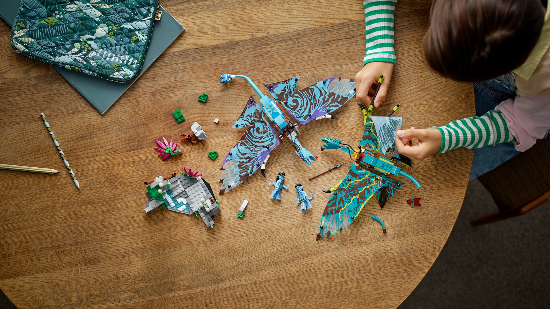Image of a kid assembling LEGO Avatar Jake & Neytiri’s First Banshee Flight set