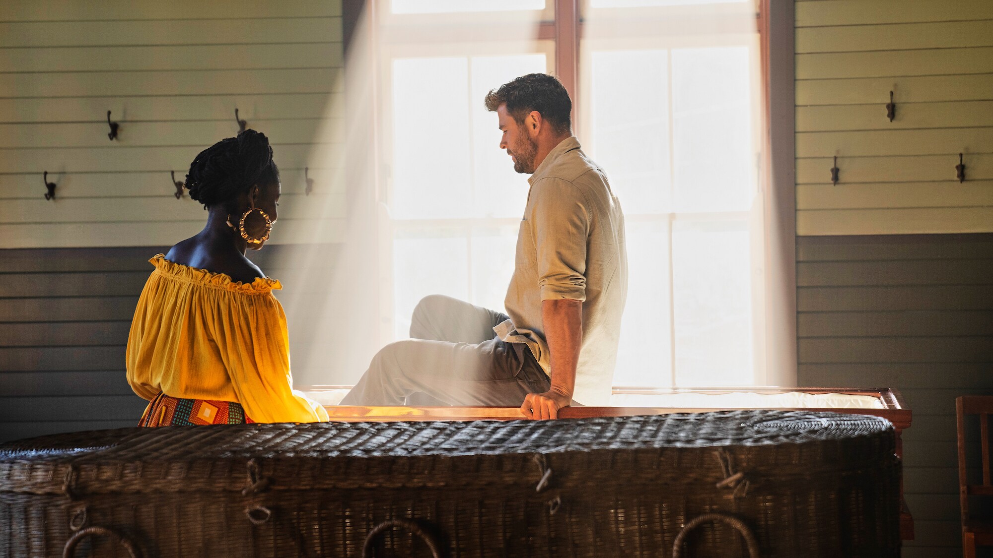 Chris Hemsworth confronts mortality and meets his death doula, Alua Arthur to try out different coffins.  (National Geographic for Disney+/Craig Parry)