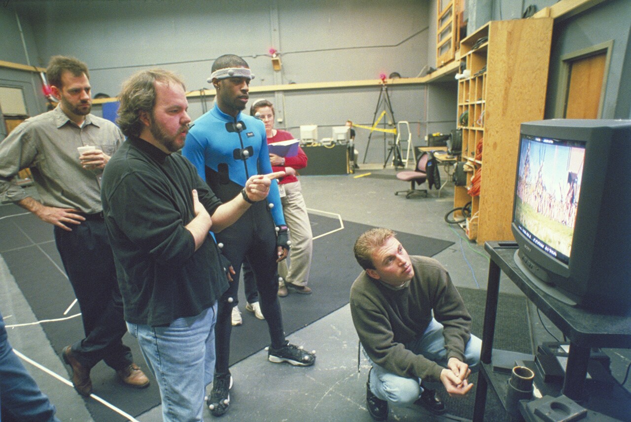 Ahmed Best looking at The Phantom Menace film while in a motion capture suit