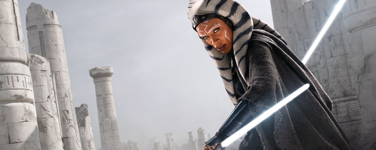 Rosario Dawson as Ahsoka Tano stands with lightsabers ignited.