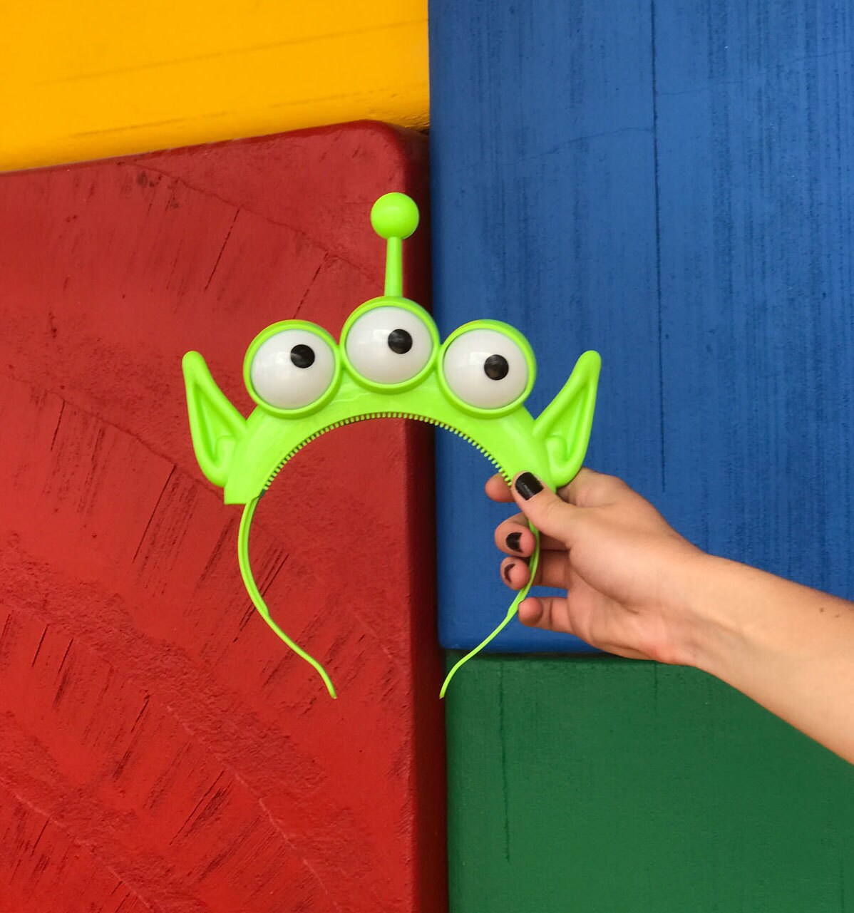 Alien Headband in front of block wall at Toy Story Land in Walt Disney World