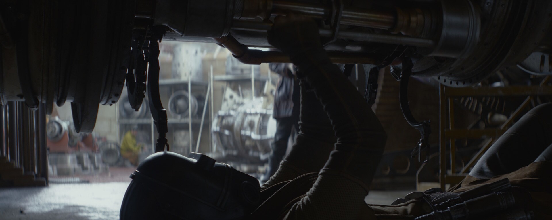 Bix Caleen (Adria Arjona) works on a piece of machinery.