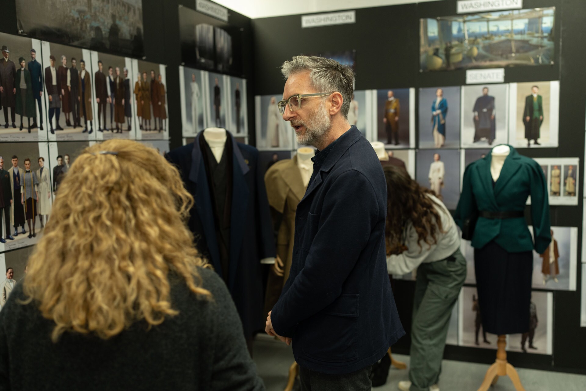 Michael Wilkinson with Ghorman costumes and concept art in the Andor costume department.
