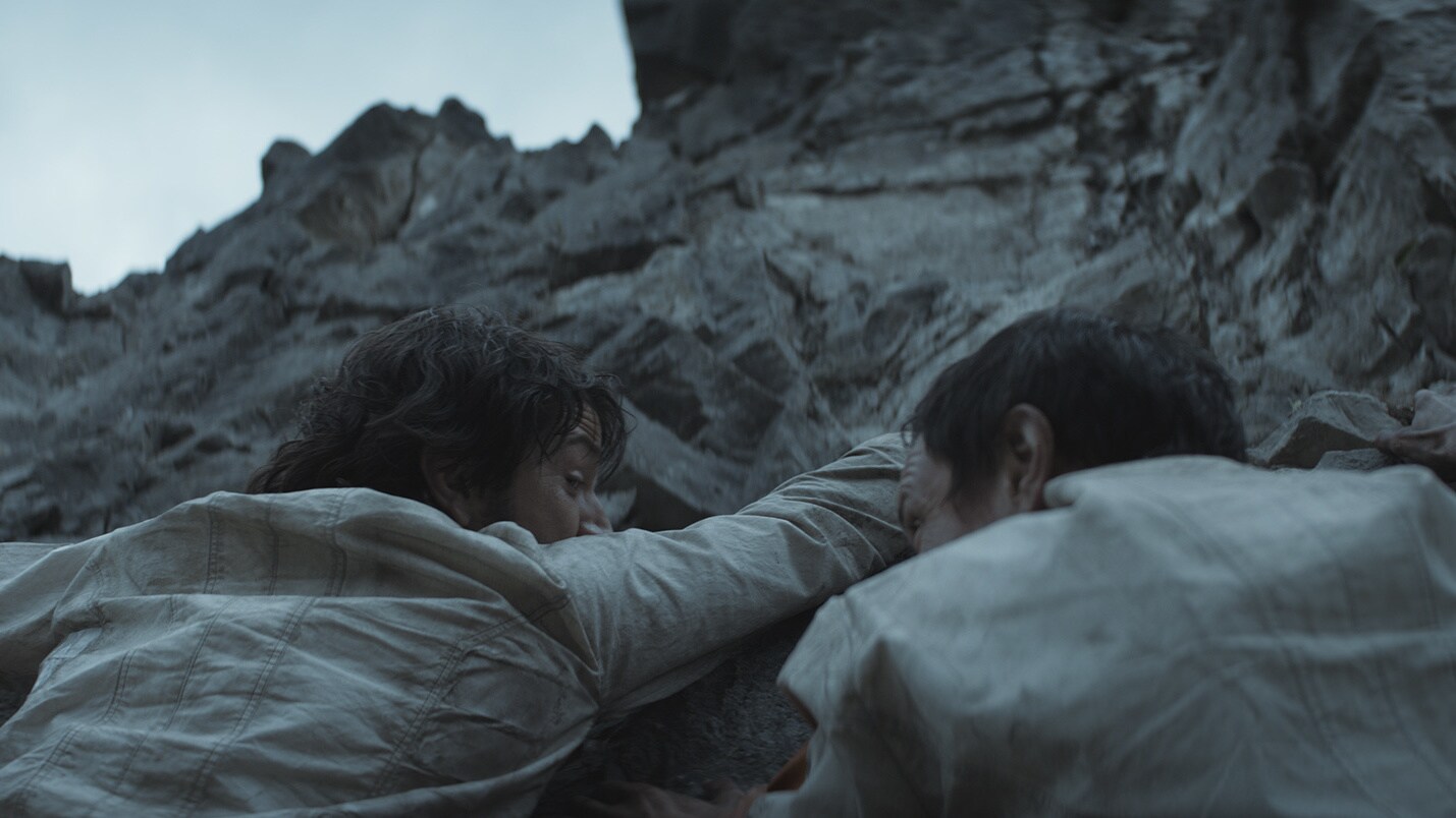 Cassian Andor and Ruescott Melshi, having reached land, wait along a dried-out quarry for Imperia...
