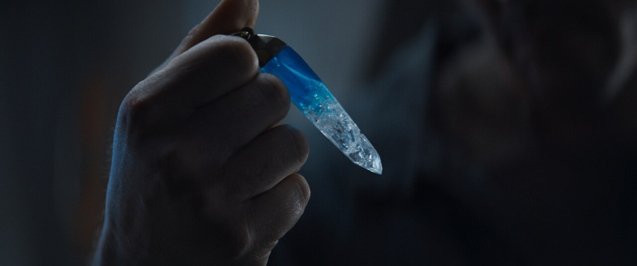 Cassian Andor holds a kyber crystal.