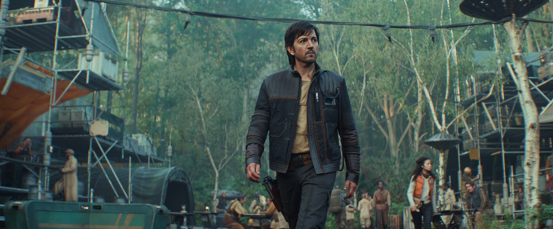 Cassian walks from his jungle home through the Rebel base to board his U-wing.