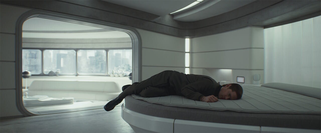 Syril Karn awkwardly lays facedown on their bed.