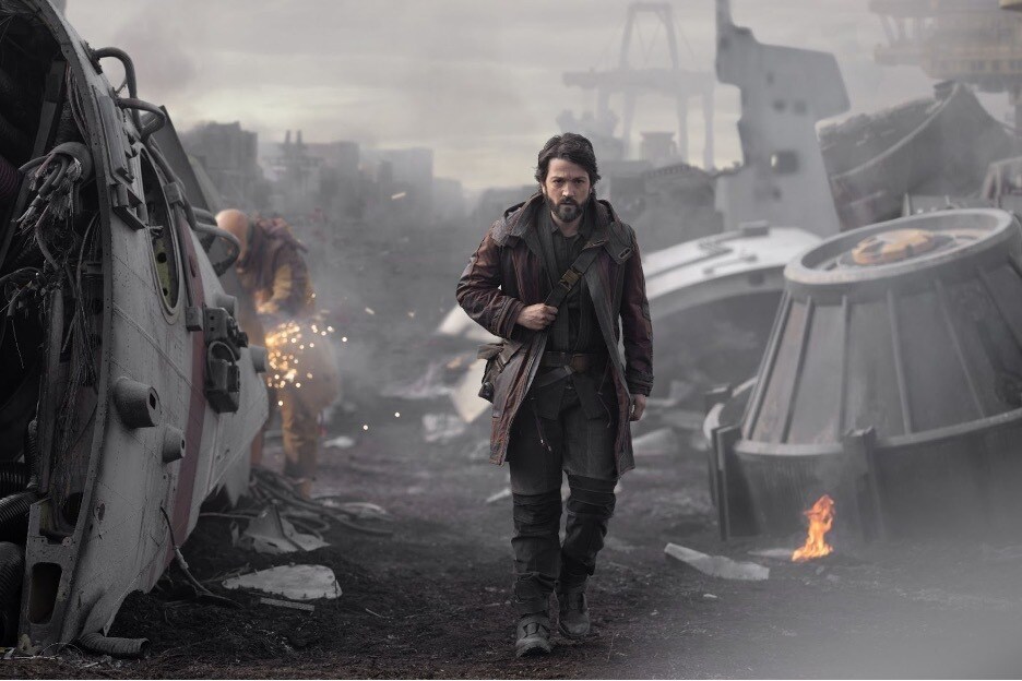 Cassian Andor walks through rubble in Andor