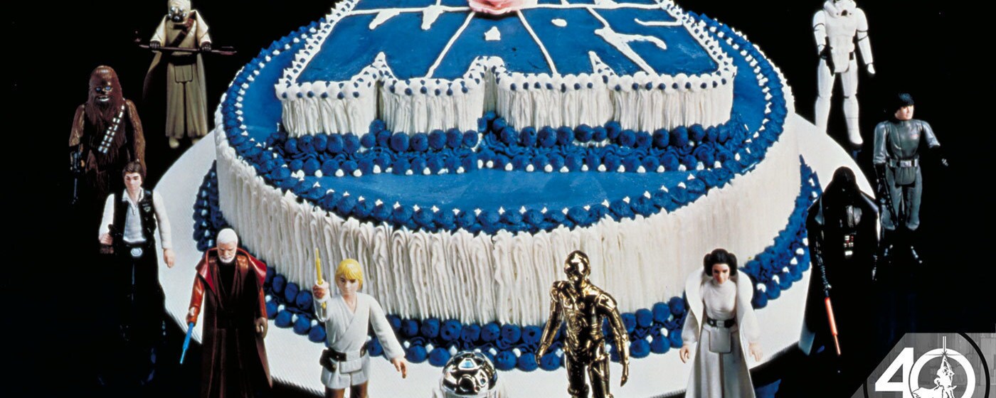 A Star Wars themed birthday cake surrounded by action figures.