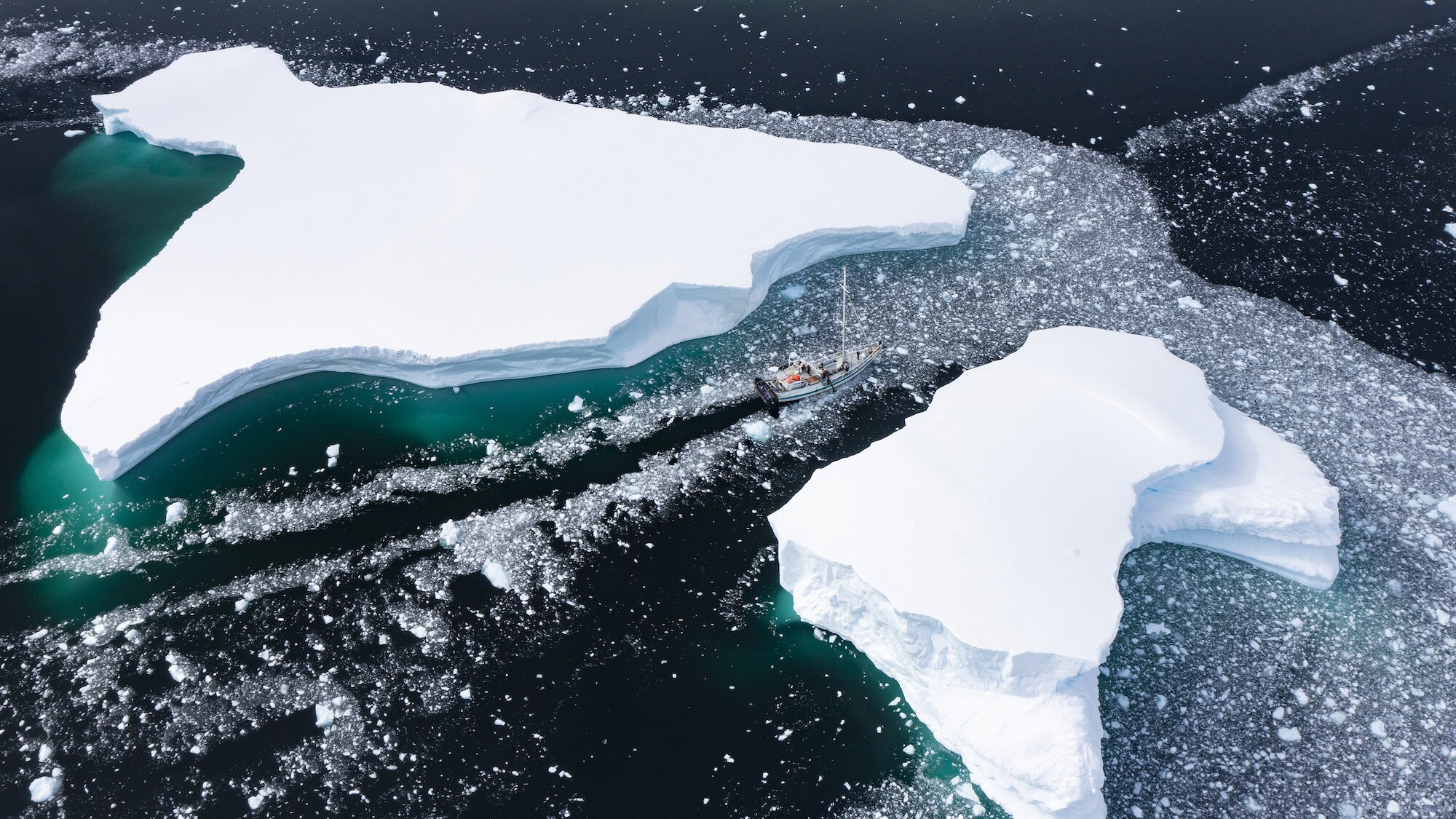 Aerial shot of the Australis sailing between two large ice sheets. (credit: National Geographic for Disney+/Bertie Gregory)
