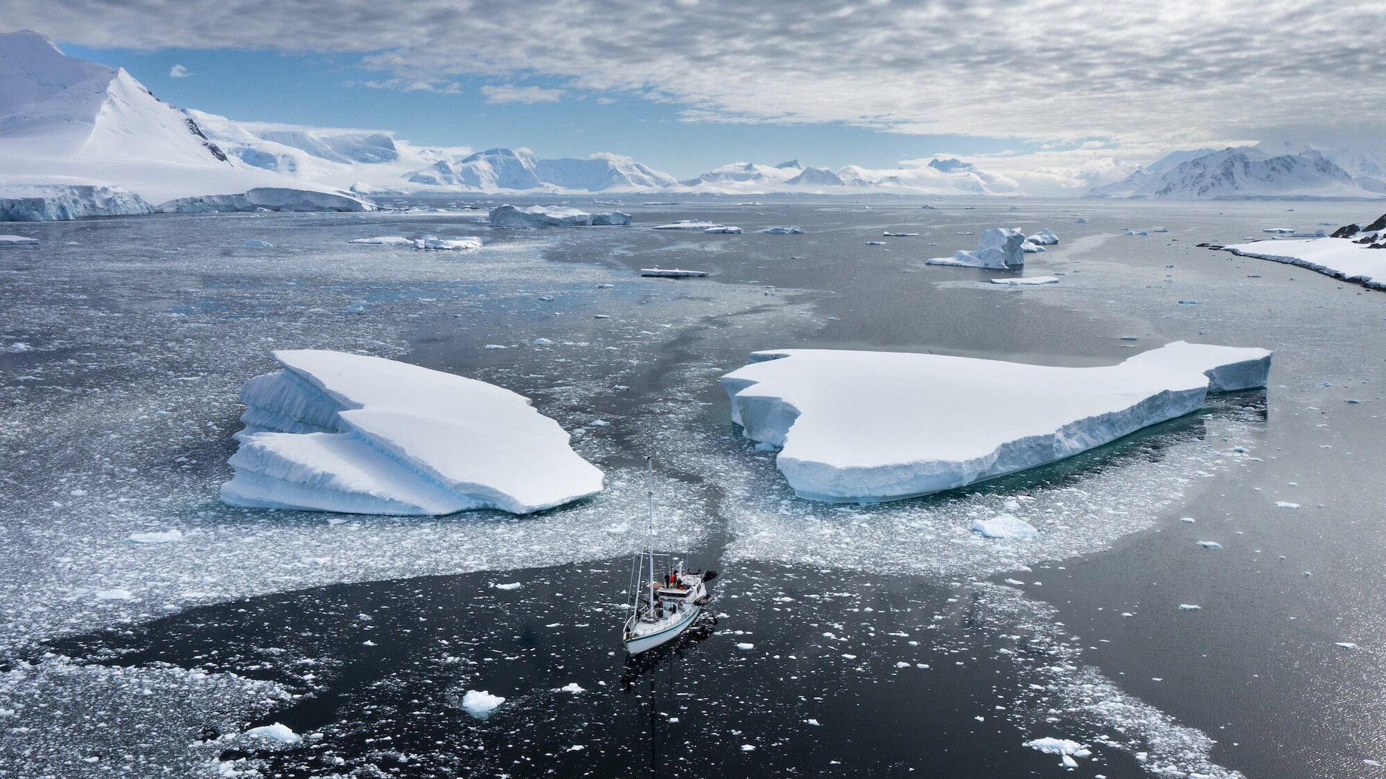 Aerial shot of Australis sailing between two large ice sheets. (credit: National Geographic for Disney+/Bertie Gregory)