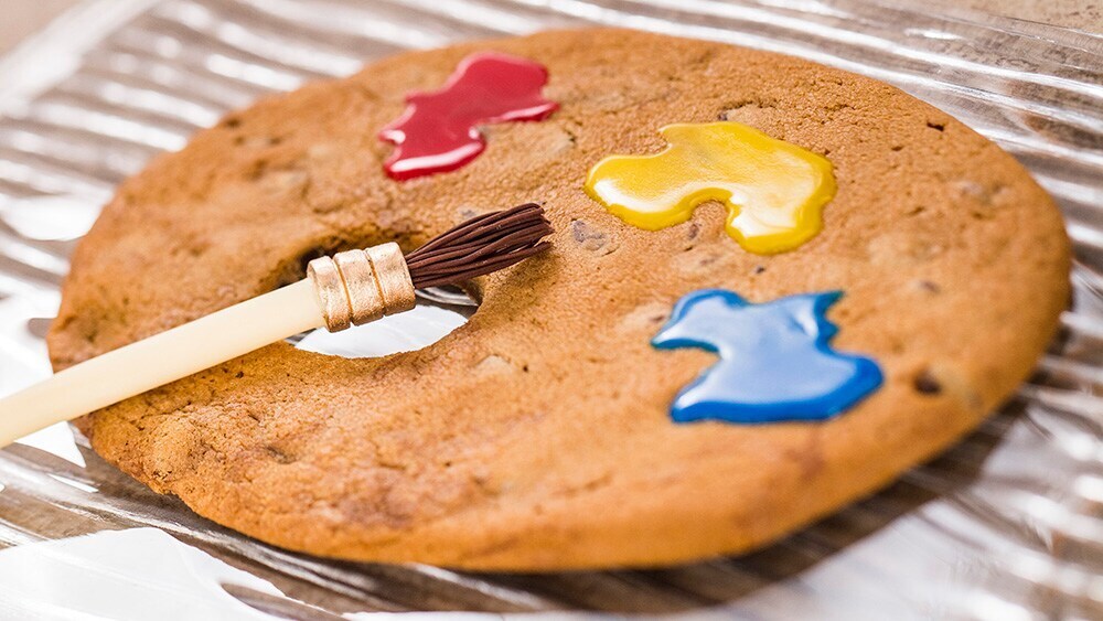 Image of cookie palette featuring a brush and frosting that looks like blue, yellow and red paint